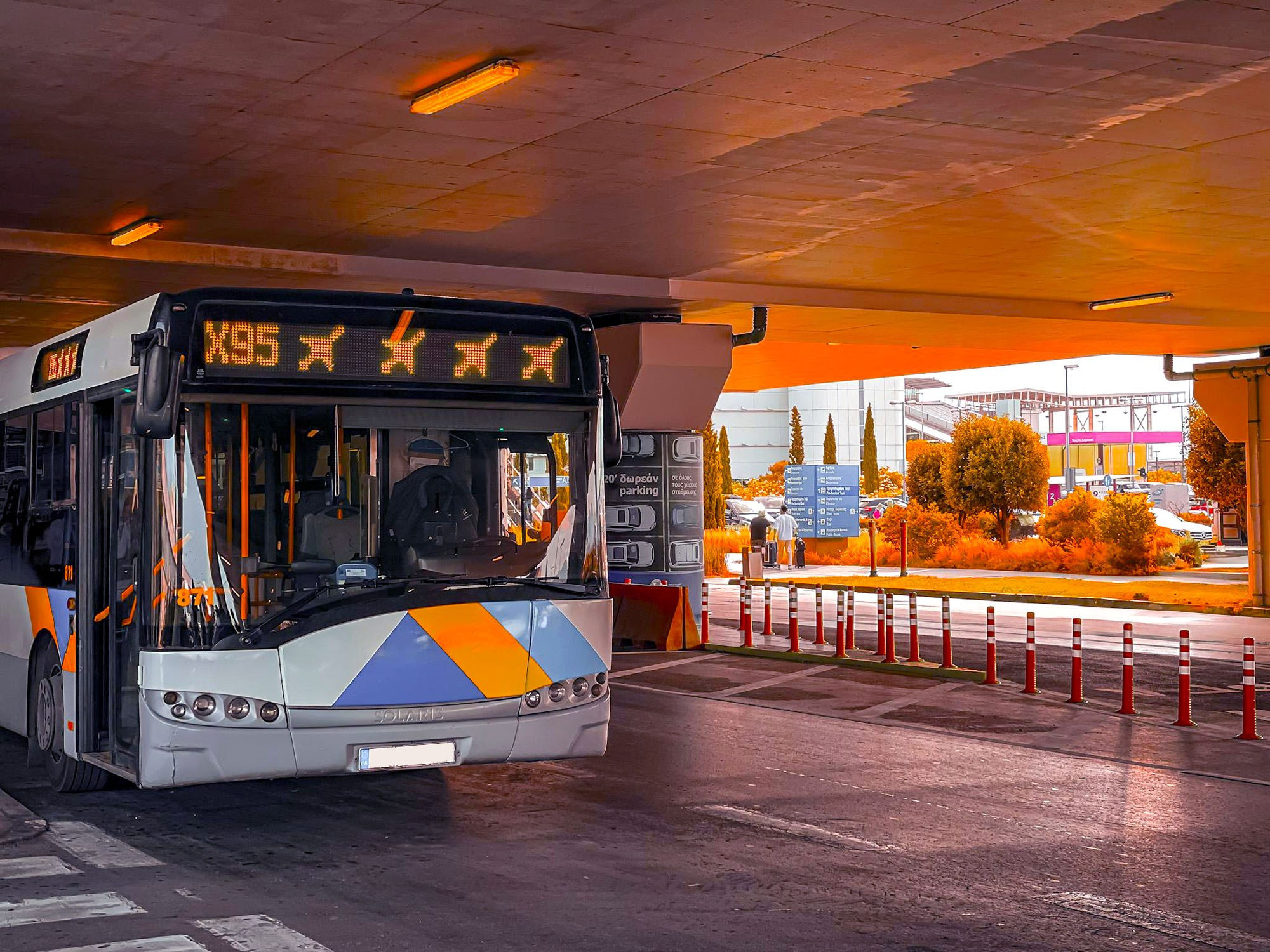 Athens Airport X95 express bus to Syntagma Square, parked at terminal for budget-friendly city center transfer.