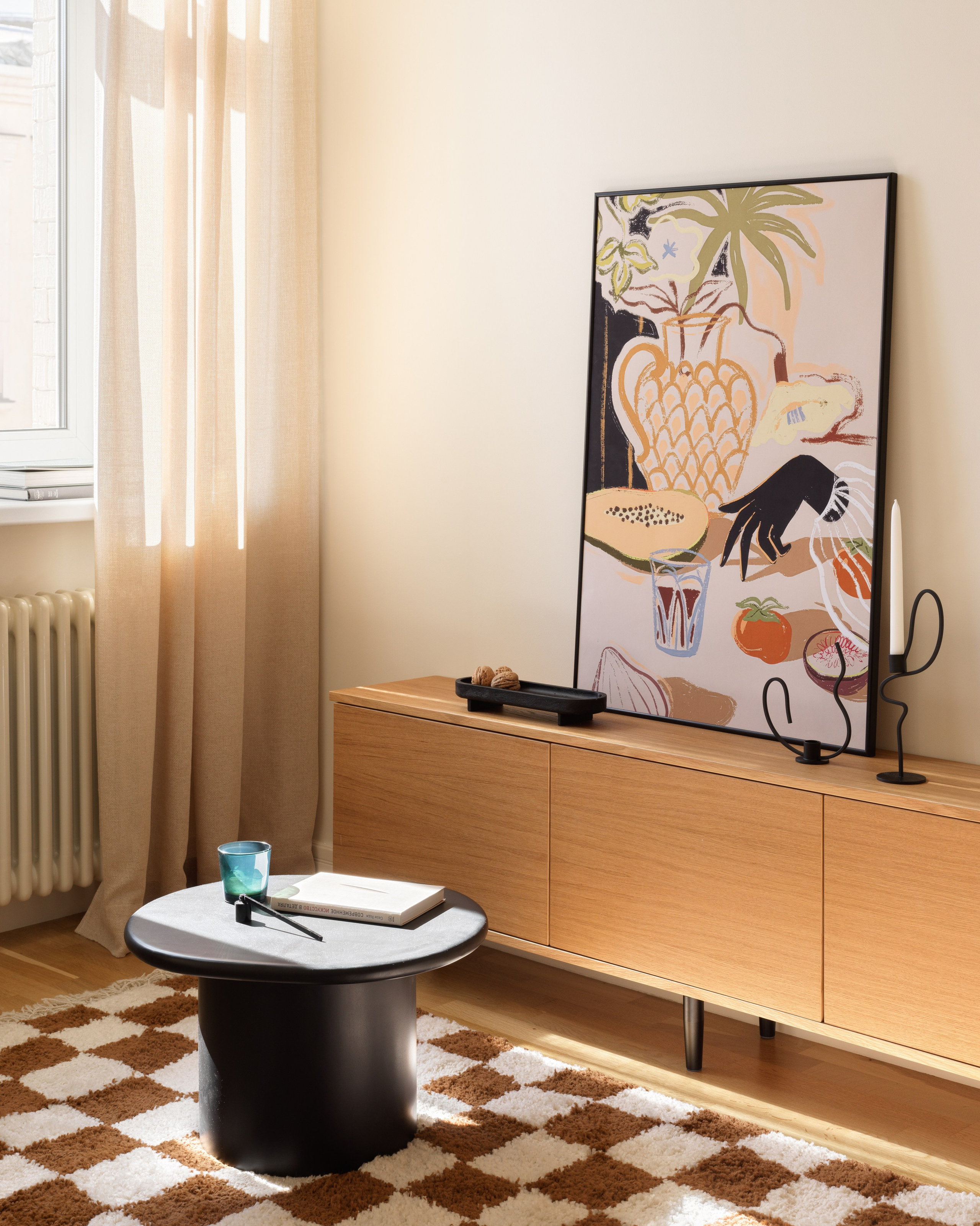 Гостиная со шпонированной ТВ тумбой и деревянным круглым журнальным столом.