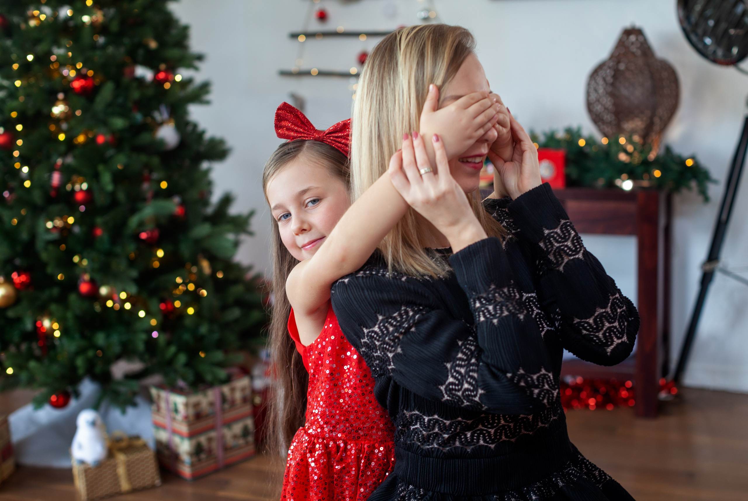 Mère et fille jouent lors d’une séance photo de Noël chaleureuse à la maison, photographie lifestyle en famille.