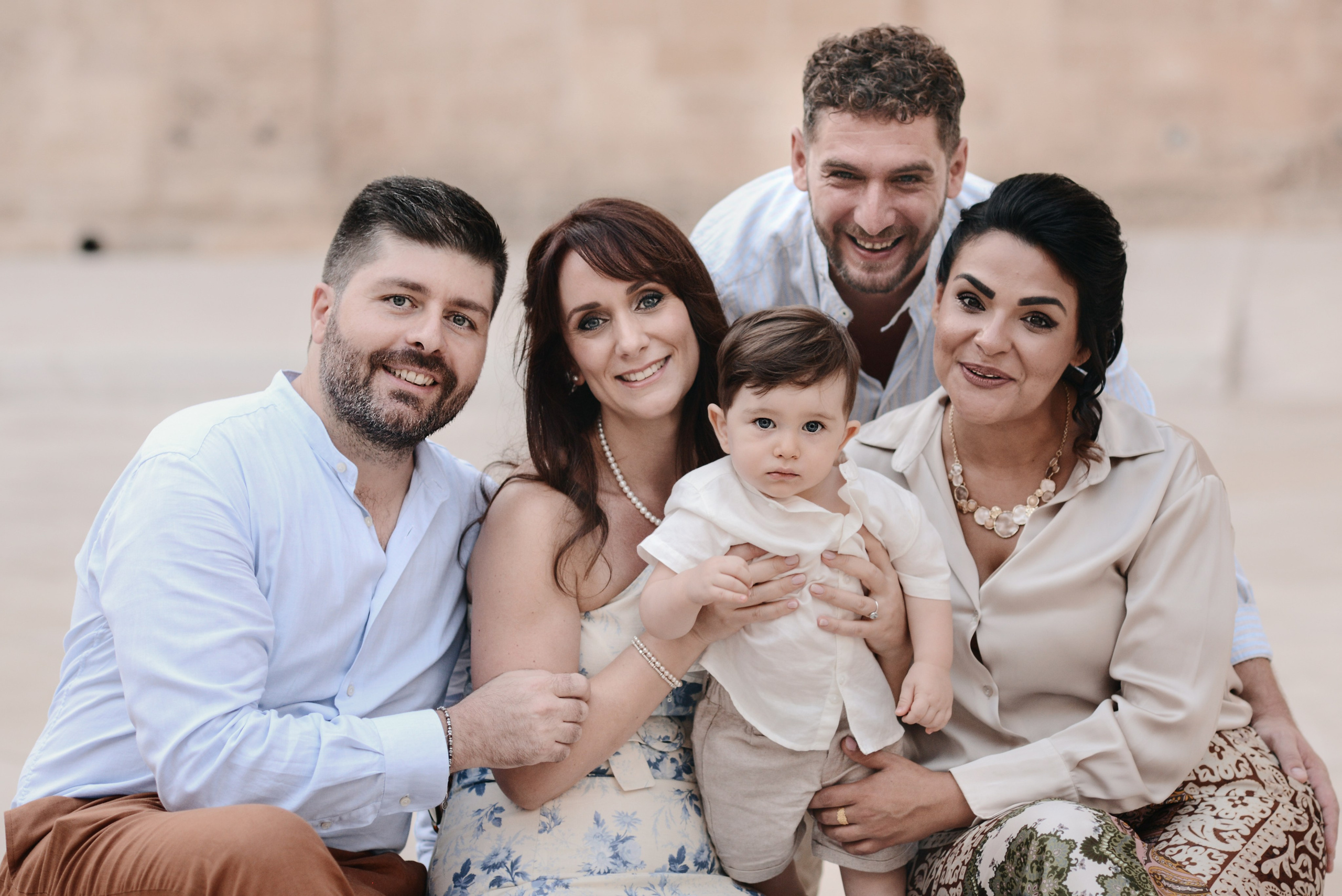 Family portrait during a vacation photoshoot in Southern Italy — smiling relatives with a baby.