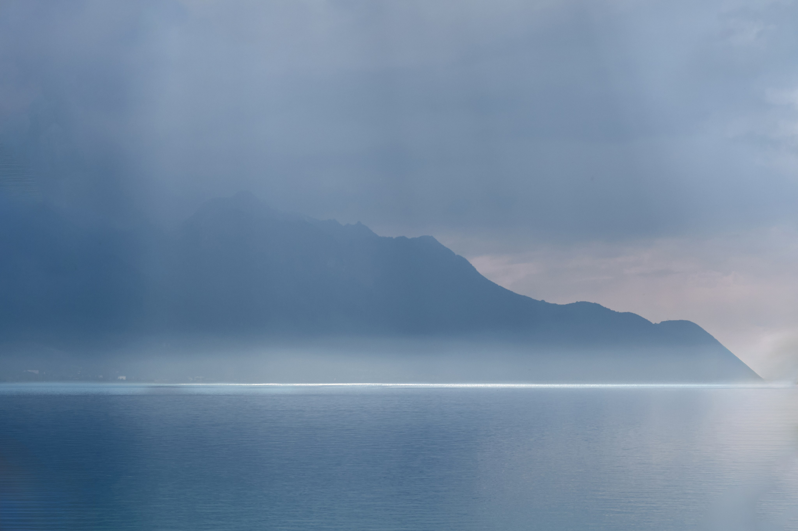 Misty sea coastline with mountain landscape.