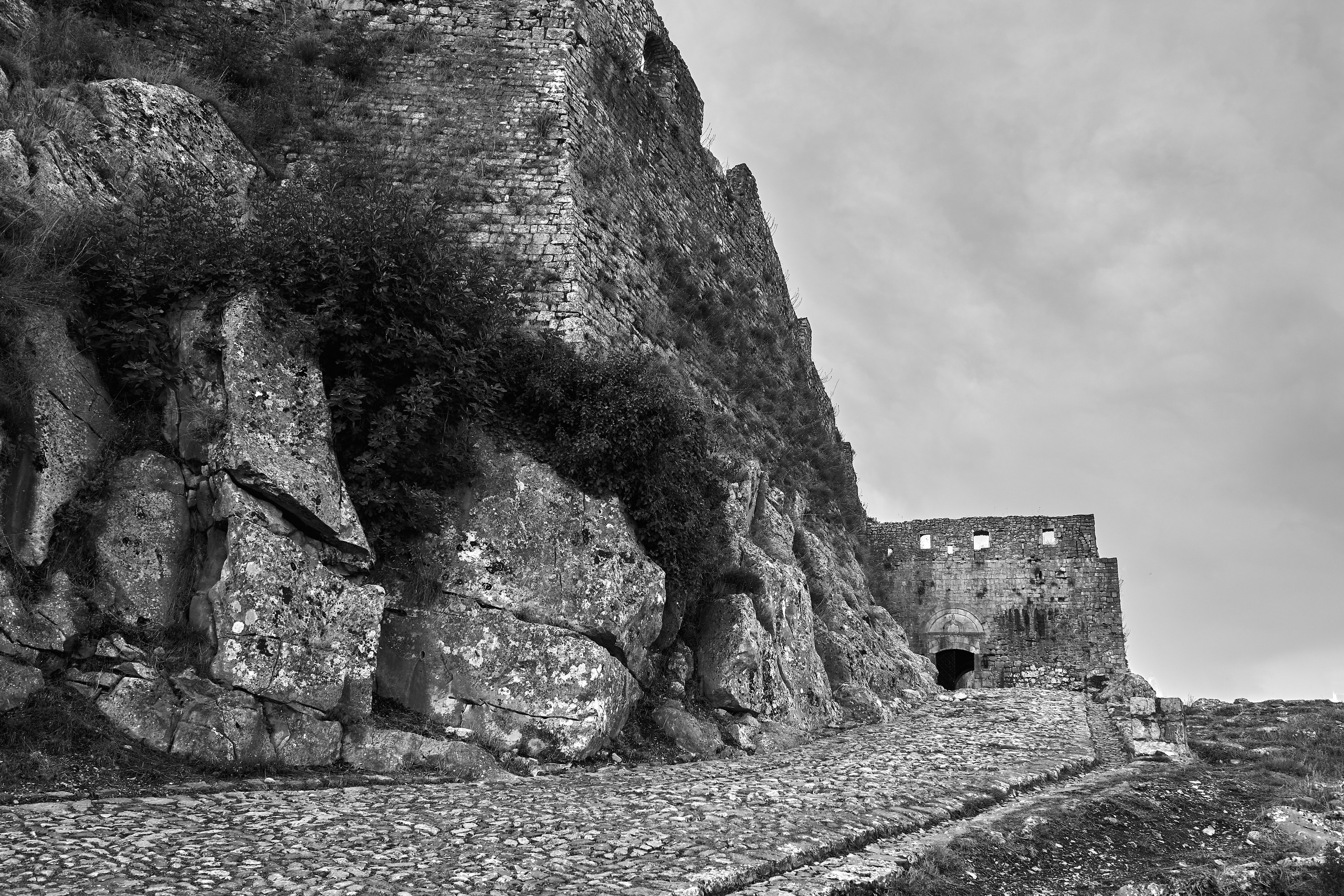 Камень давит сверху, дорога уходит вглубь. Арт-фотография, где древняя крепость становится вопросом без ответа