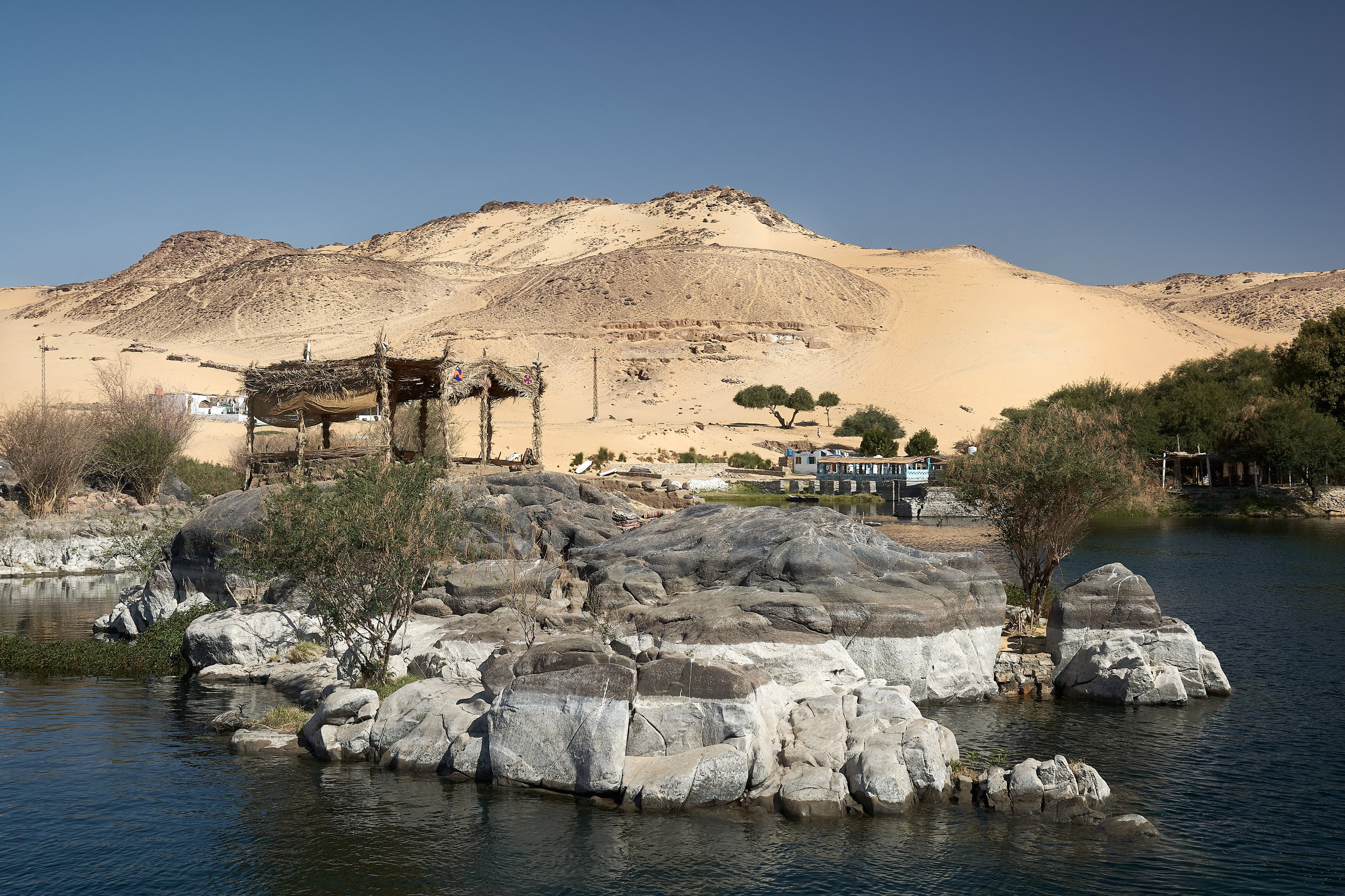 Rocky Nile island with desert dunes beyond