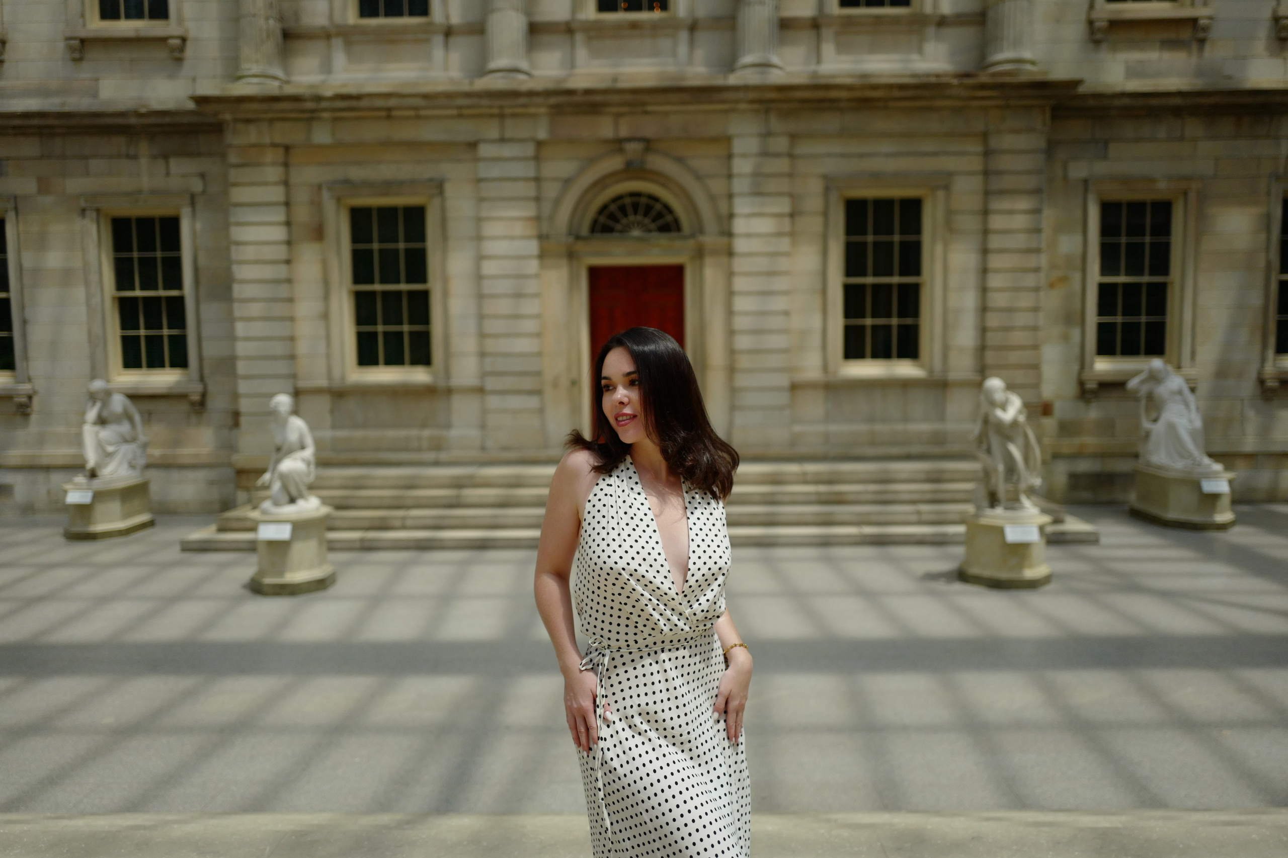 a woman in a dress standing in front of a building