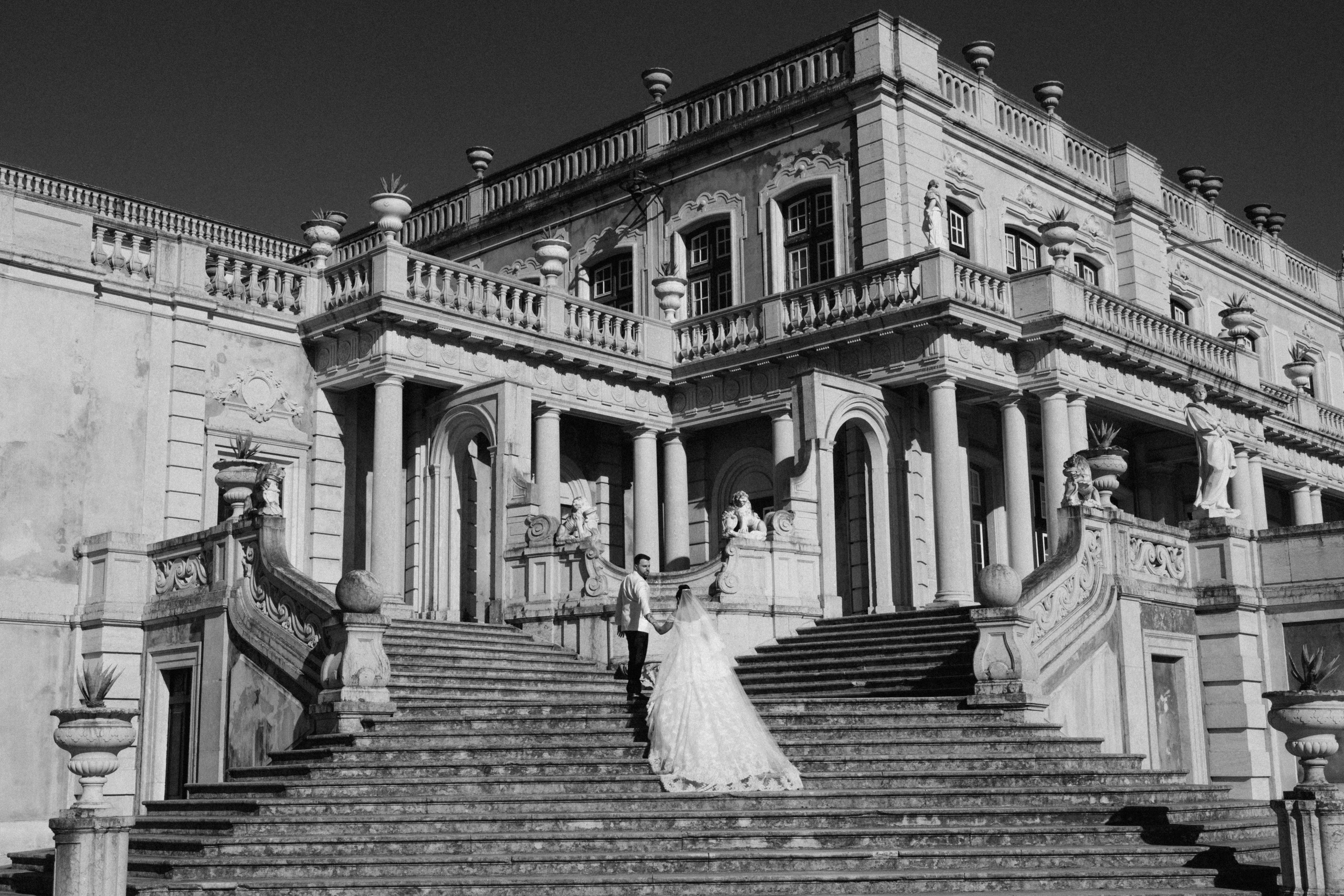 Casal a subir a escadaria do Palácio de Queluz