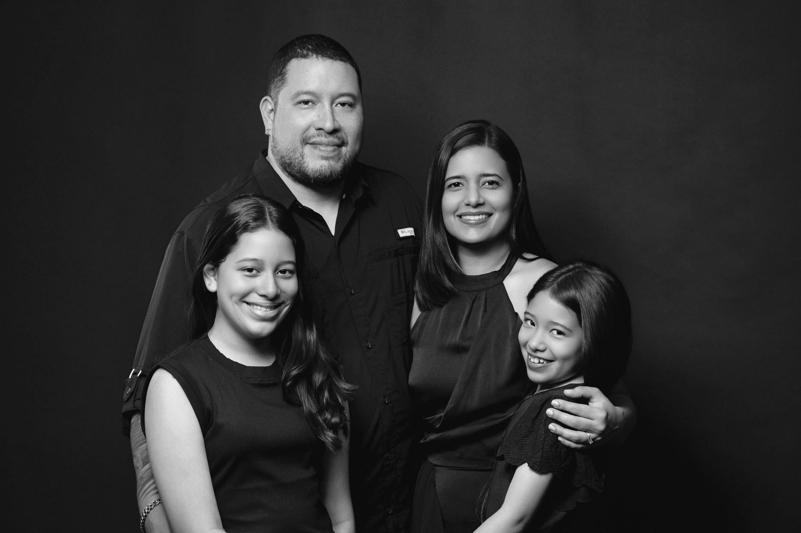 Sesión de fotos familiar en estudio en David Chiriquí con fondo negro y estilo elegante