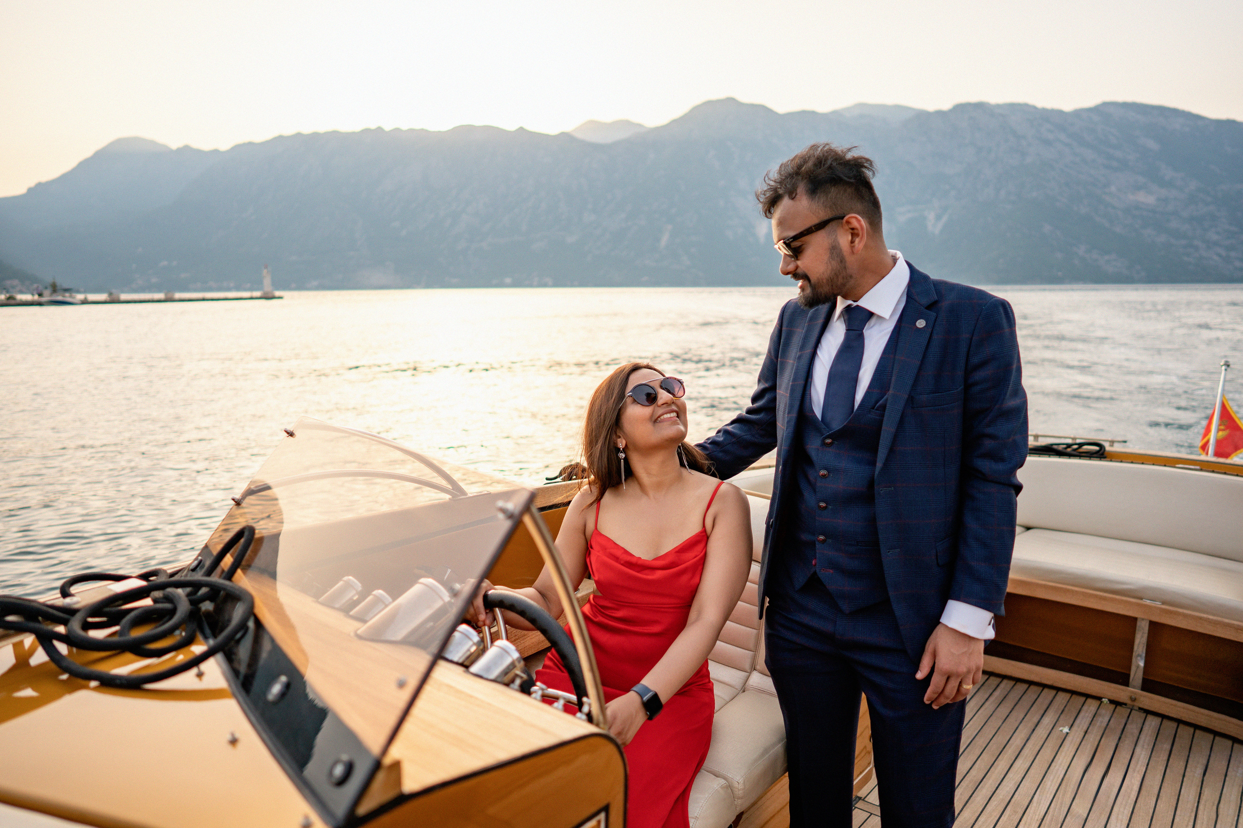 Счастливая пара на лодке во время их фотосессии в Черногории после того, как парень сделал предложение своей девушке