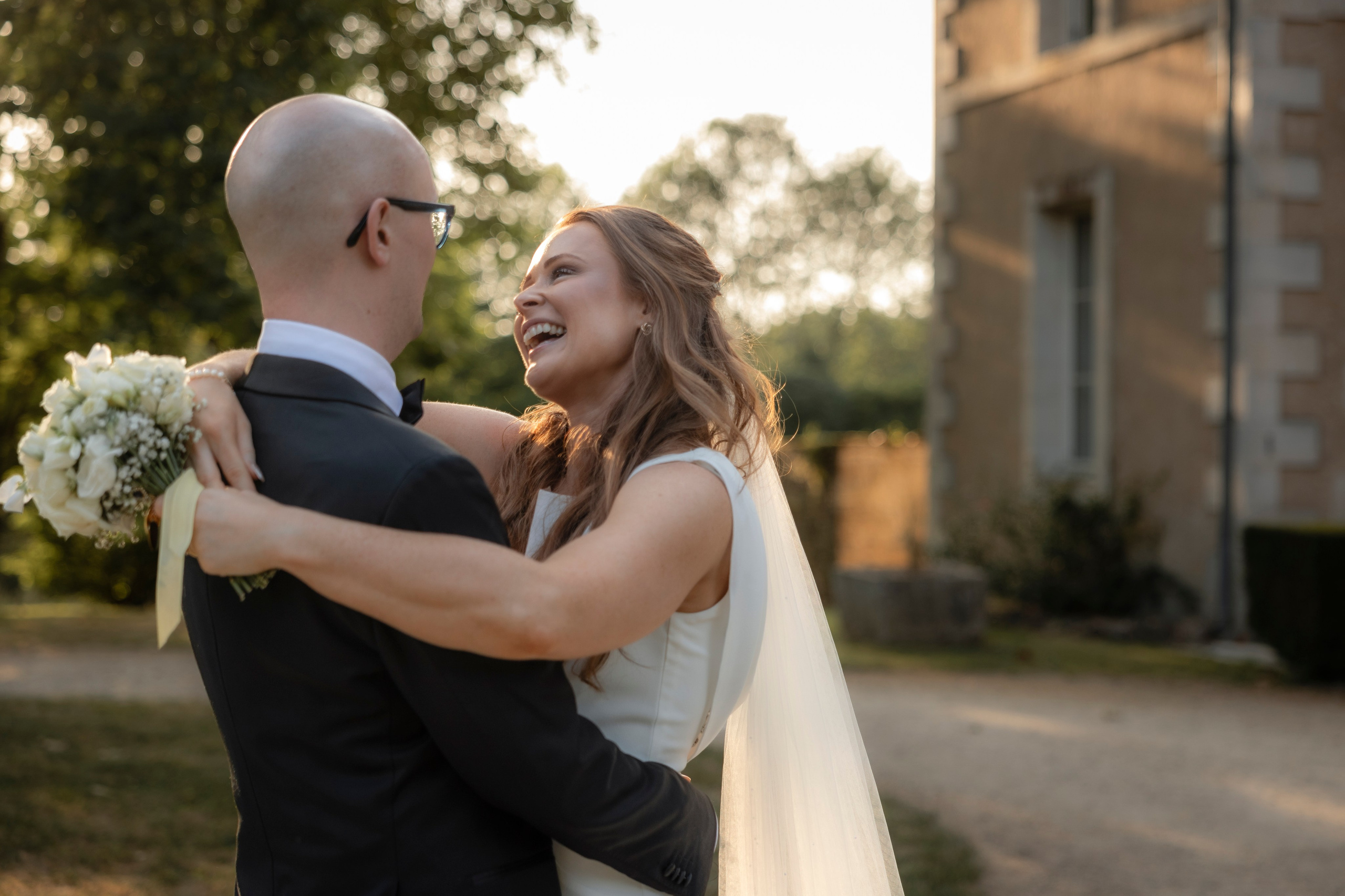Bride and groom embracing in soft afternoon light at Château Sentout during their destination wedding in France.