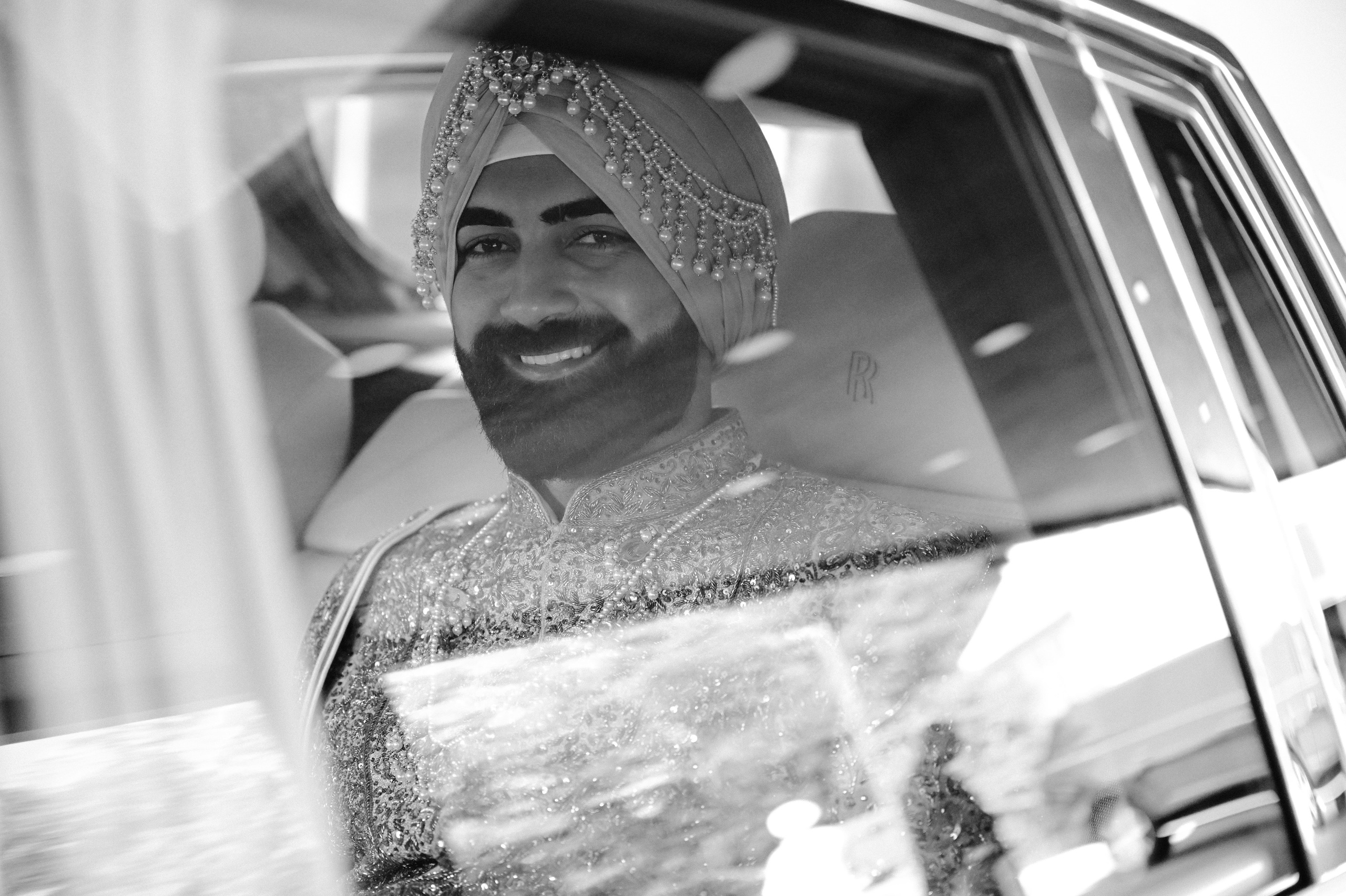 a man in a tuk is smiling and looking out the window