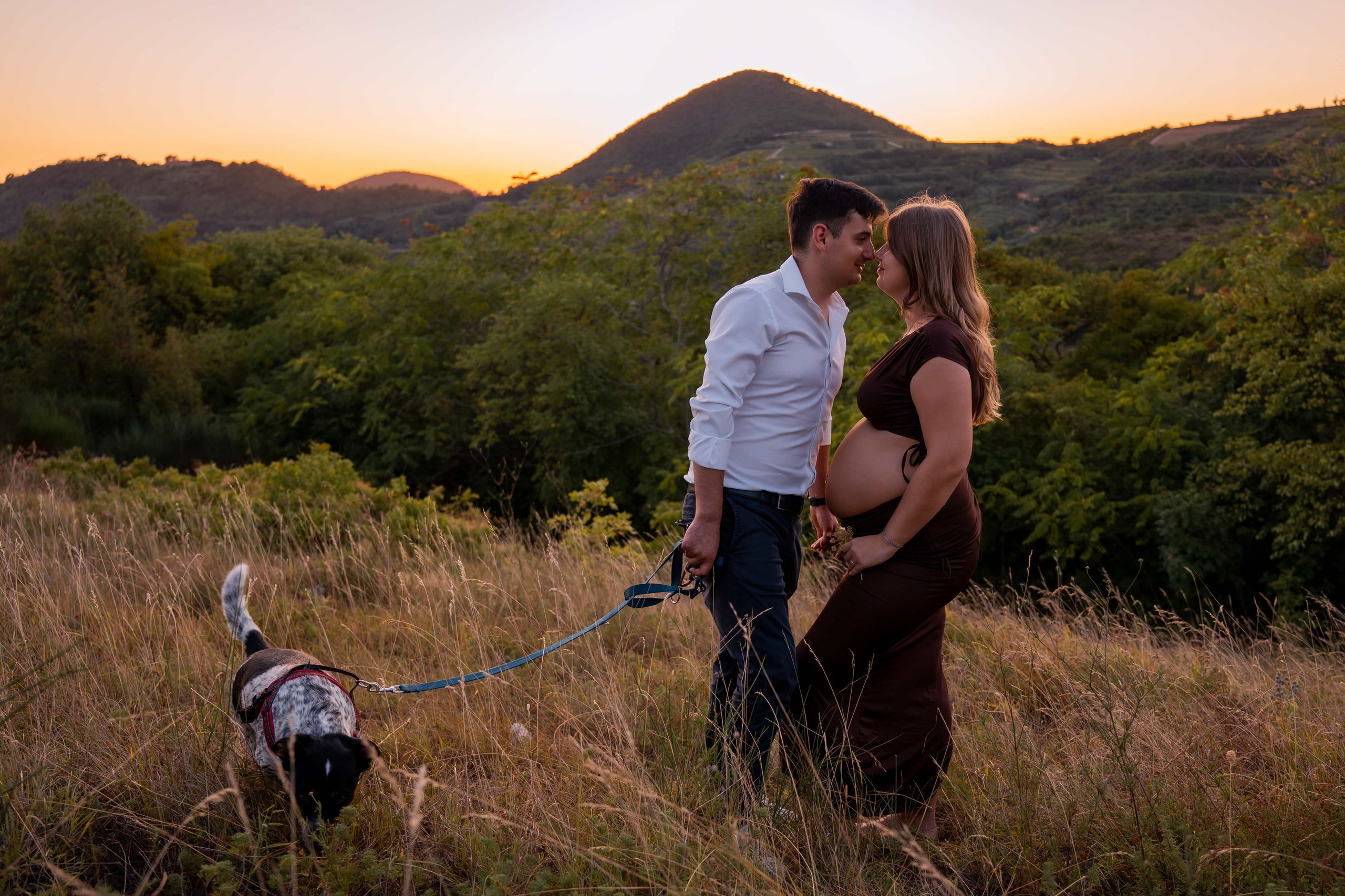 Coppia in dolce attesa durante un servizio fotografico gravidanza all'aperto al tramonto sui Colli Euganei.