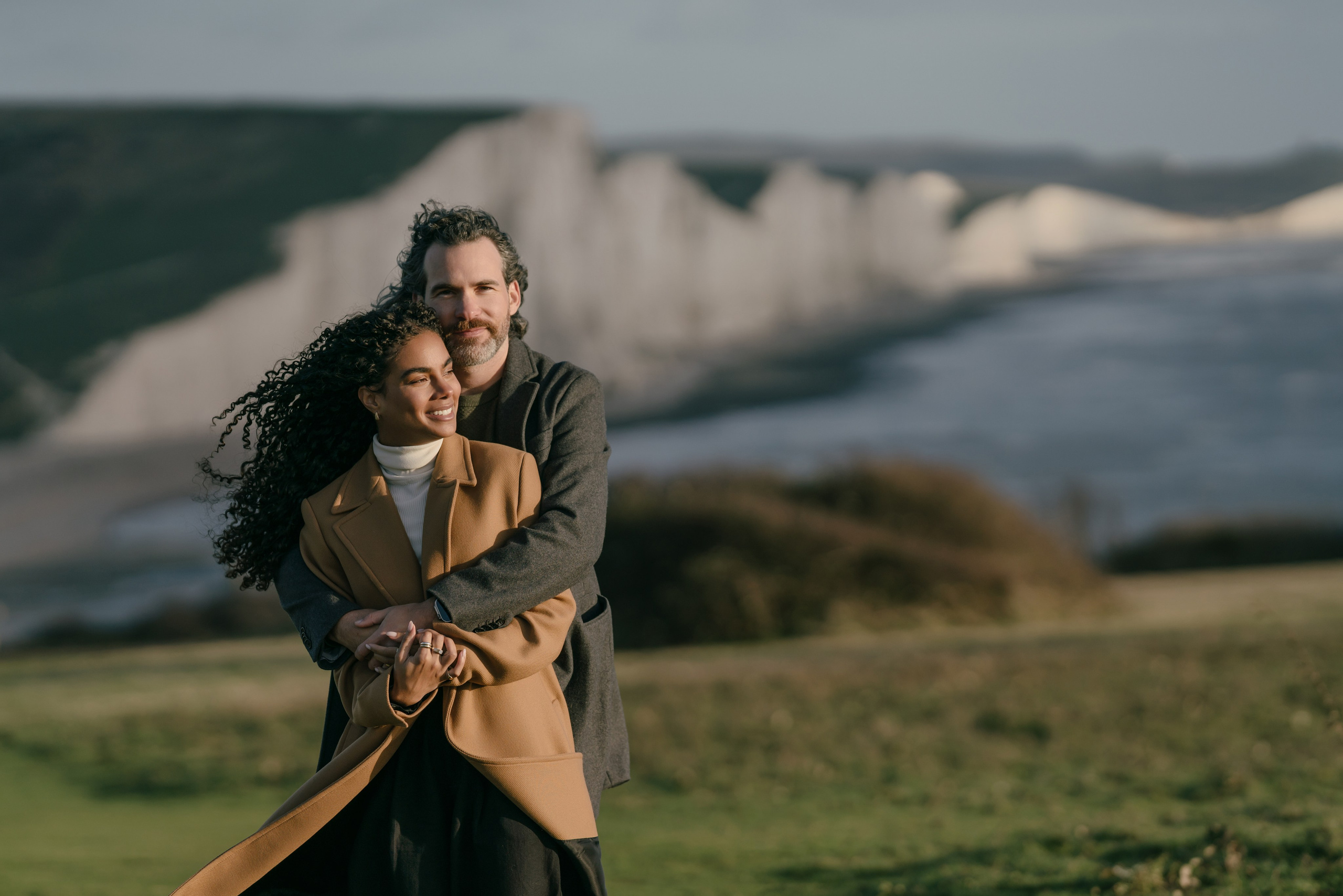 young couple hiding behind bushes in the park