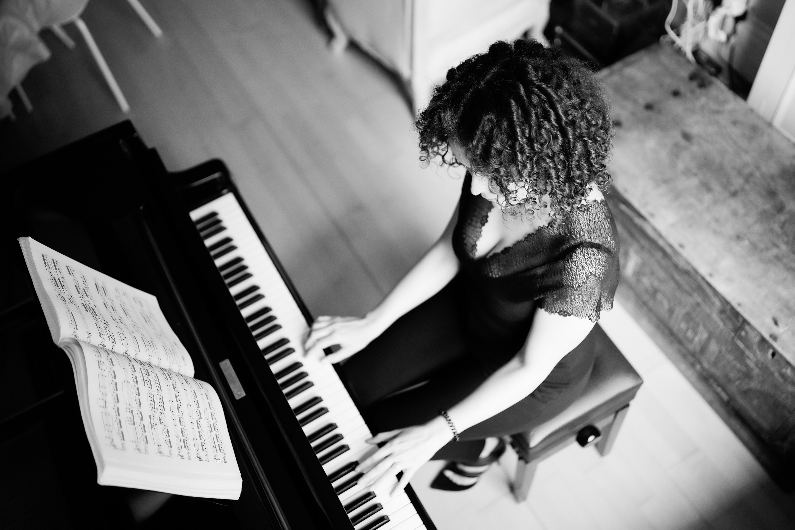 Black and white portrait of a woman playing the piano, photographed during an Artistic Discovery Session in Solihull.