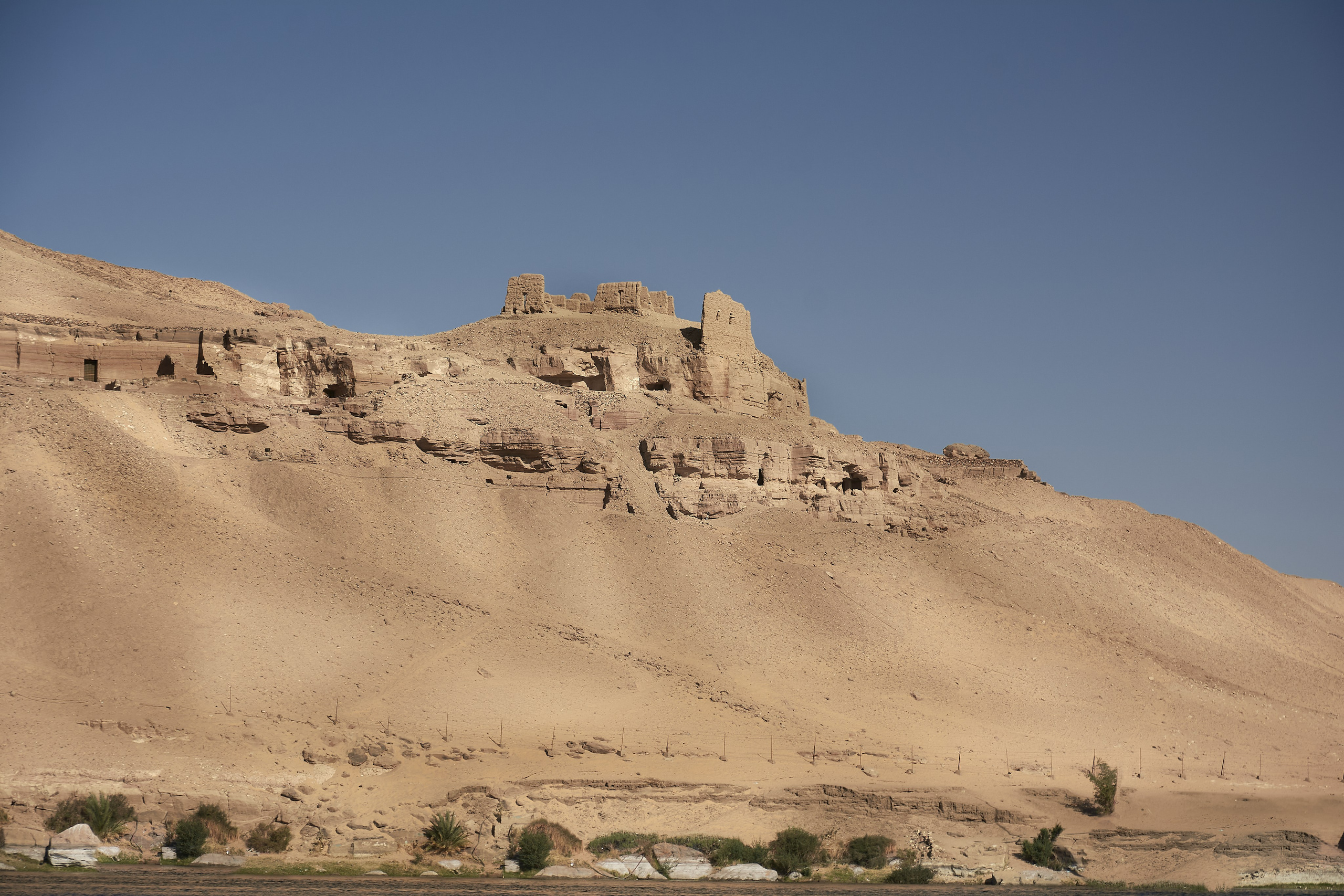 Desert cliff ruins rising above Nile valley