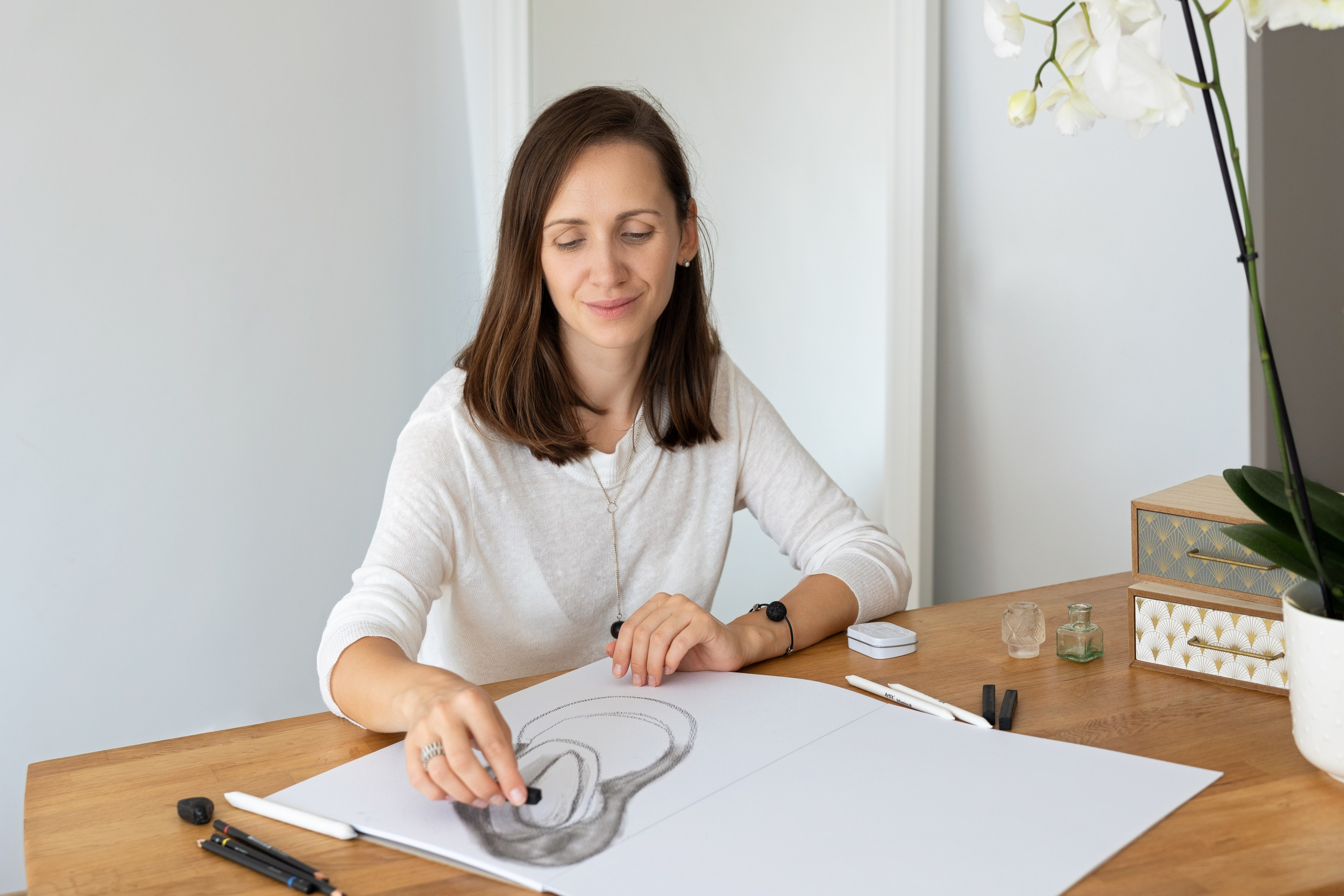 Woman in white shirt at a wooden desk writing, soft daylight personal brand portrait, Toulouse