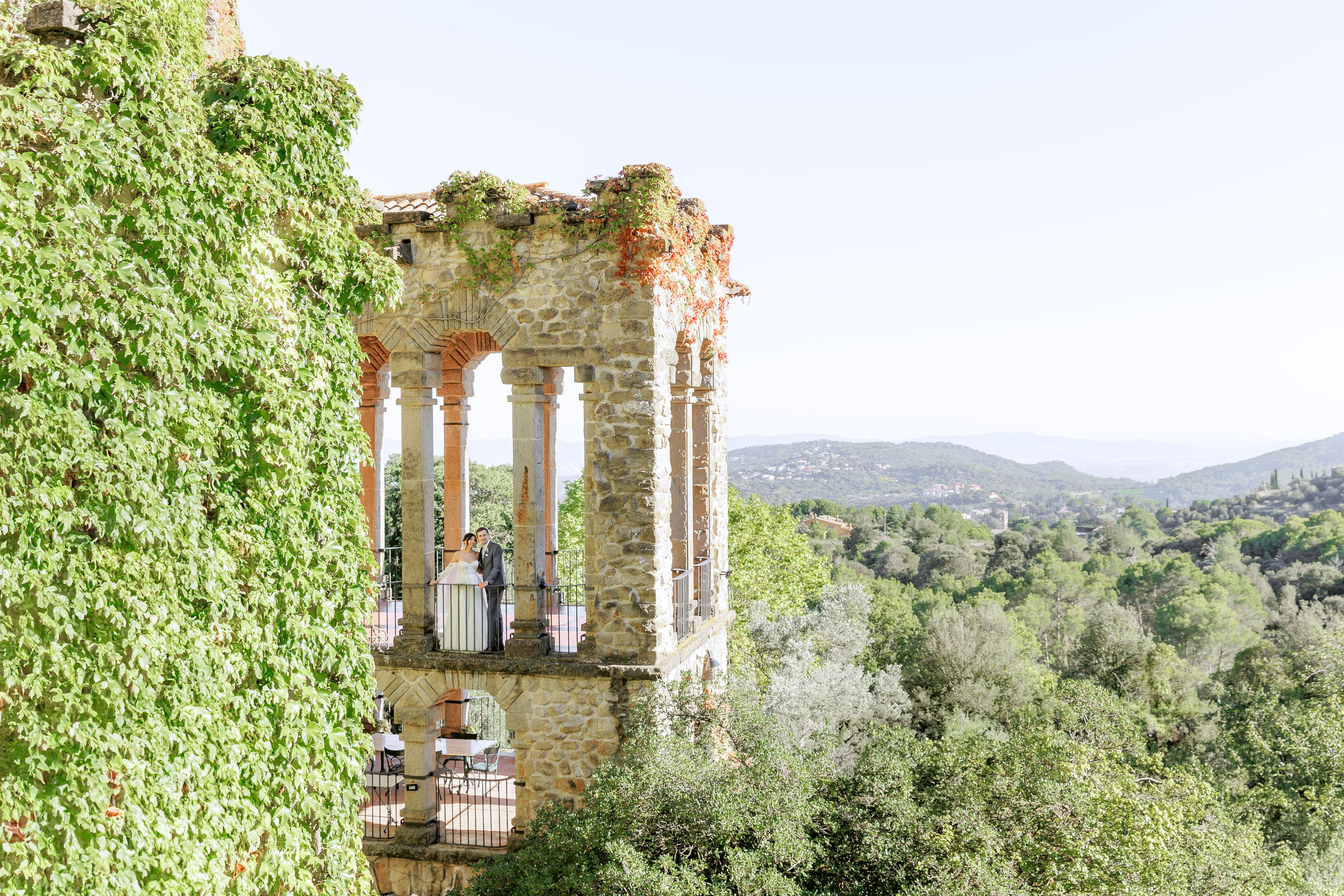 Bride and groom at the grand balcony at La Baronia, Art Nouveau wedding venue in Catalonia.