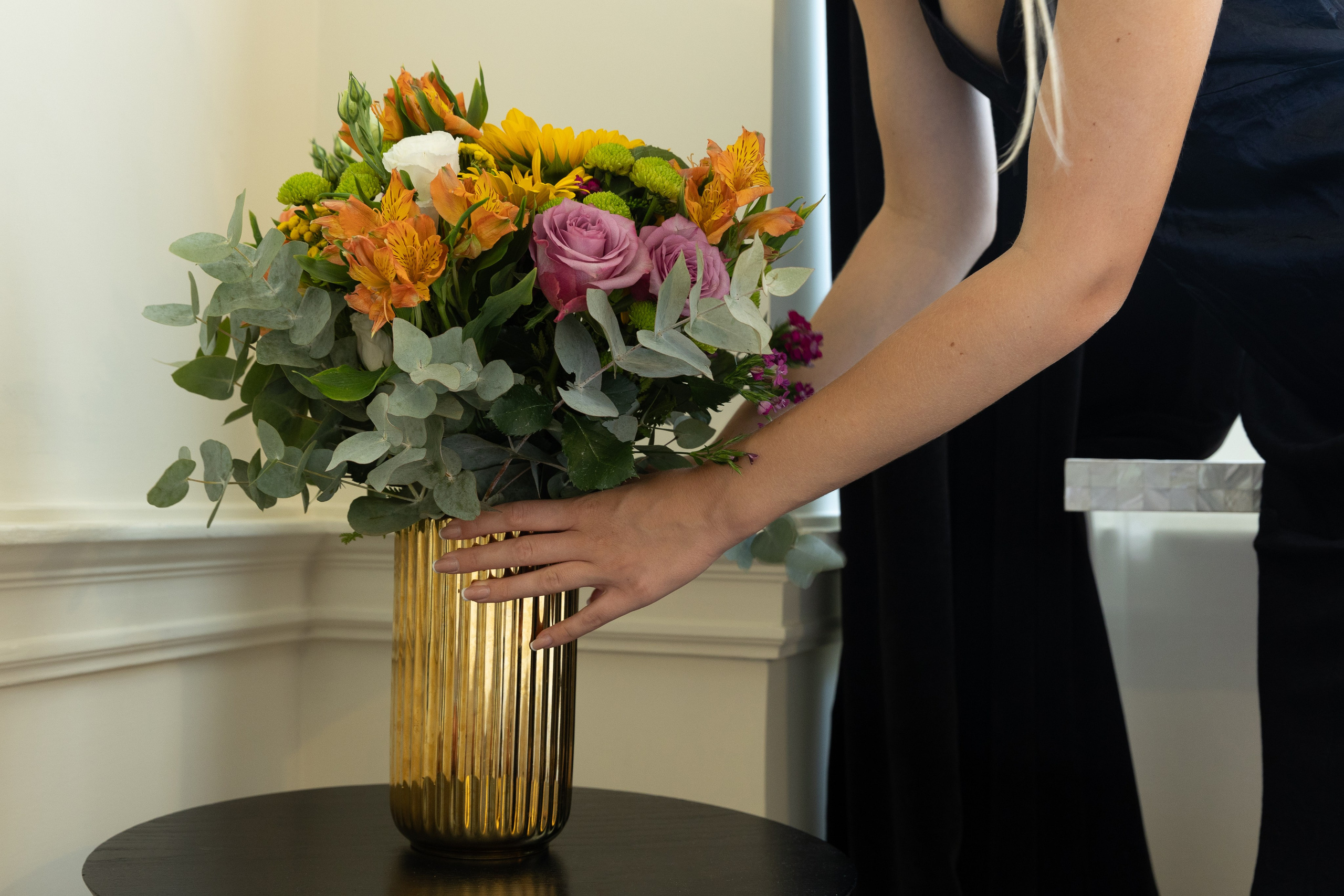Cinematic details photograph of woman with flowers in vase at Roma Luxus Hotel, Rome.