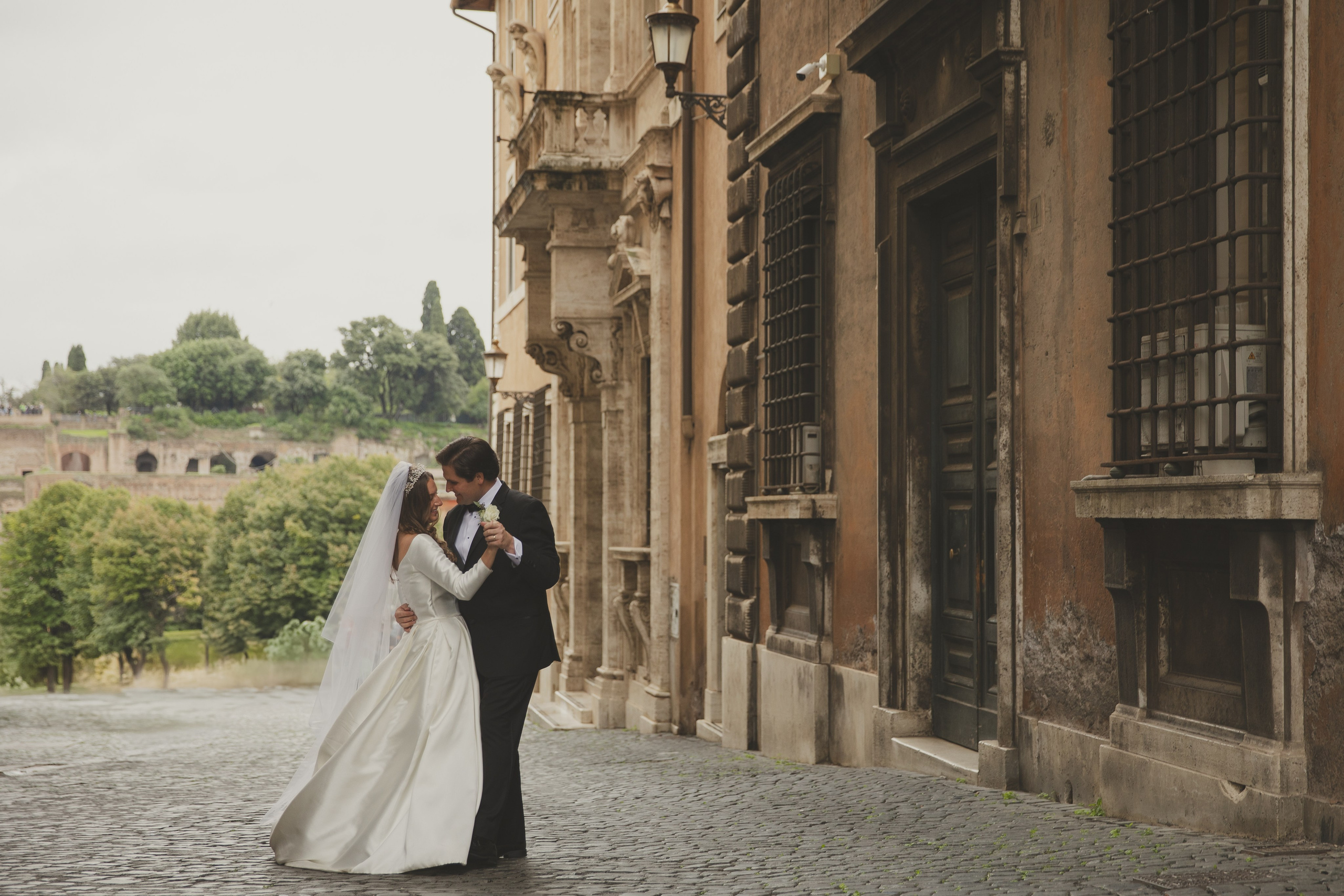 Couple walking hand-in-hand through a vineyard in Rome Forum Colosseo during golden hour.