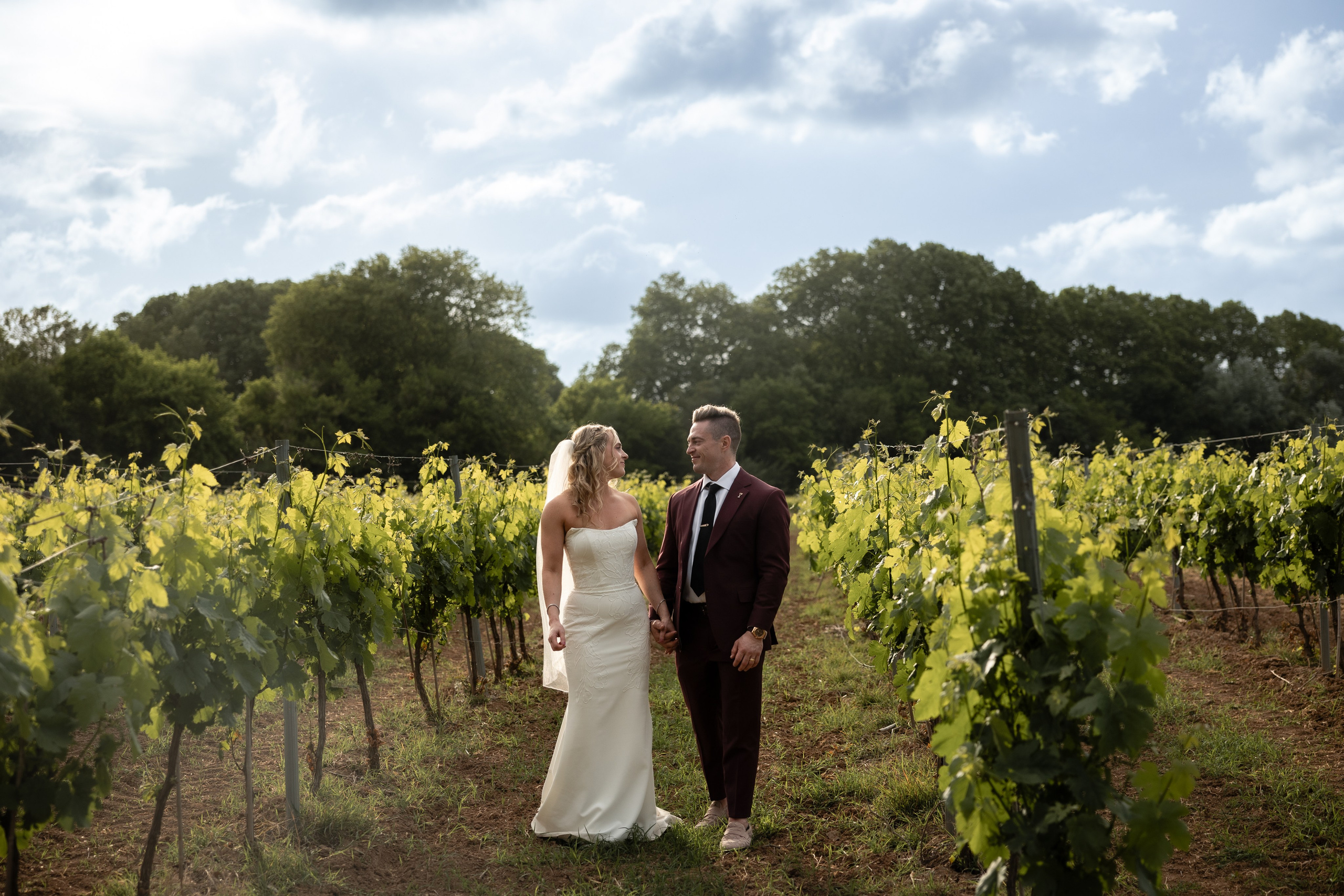 Mariés marchant dans les vignes pendant leur mariage destination en France