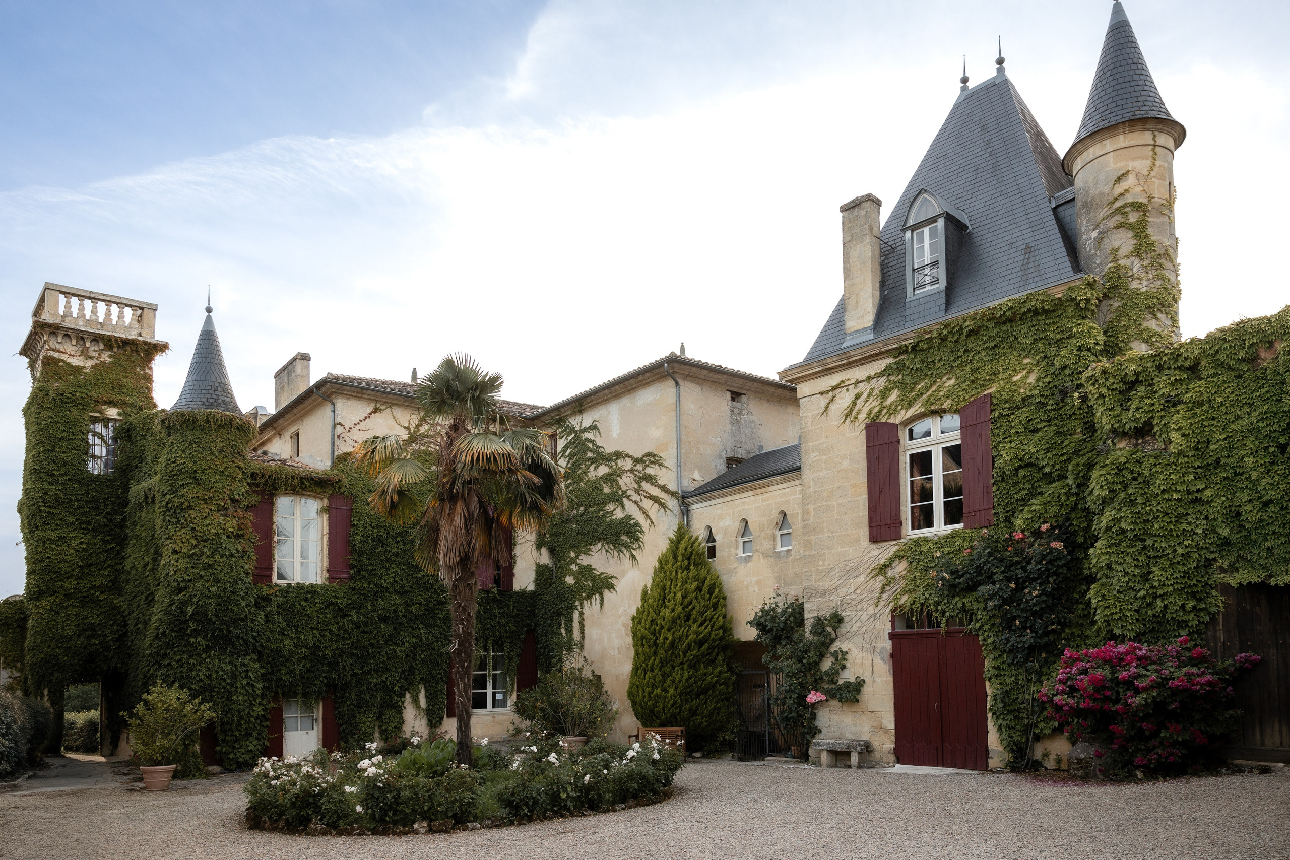 Exterior view of Château Sentout wedding venue surrounded by ivy and gardens in the Bordeaux region of Southwest France.