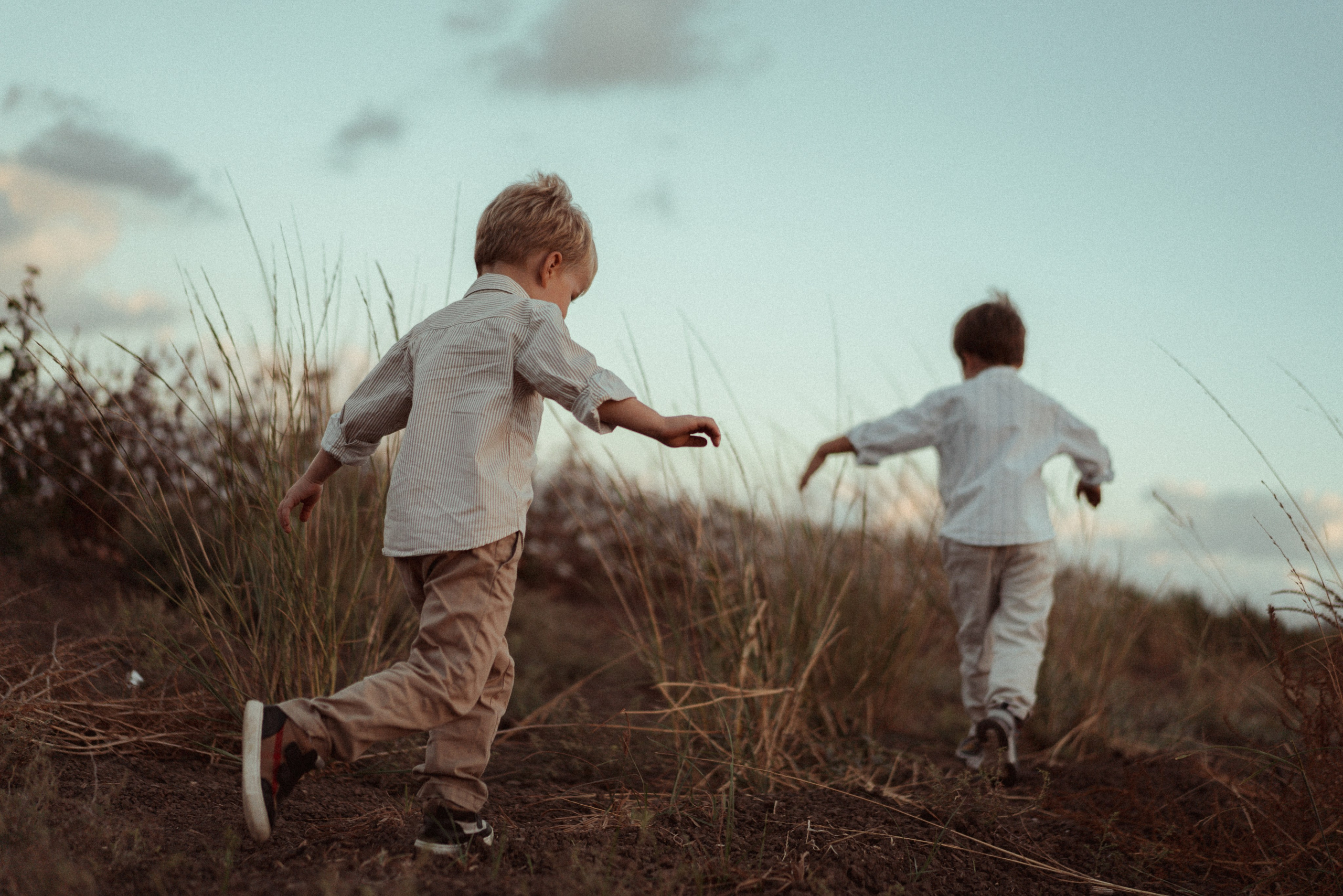 ילדים רצים בשדה, נהנים ממשחק פעיל בחוץ עם רקע של ירוק טבעי.