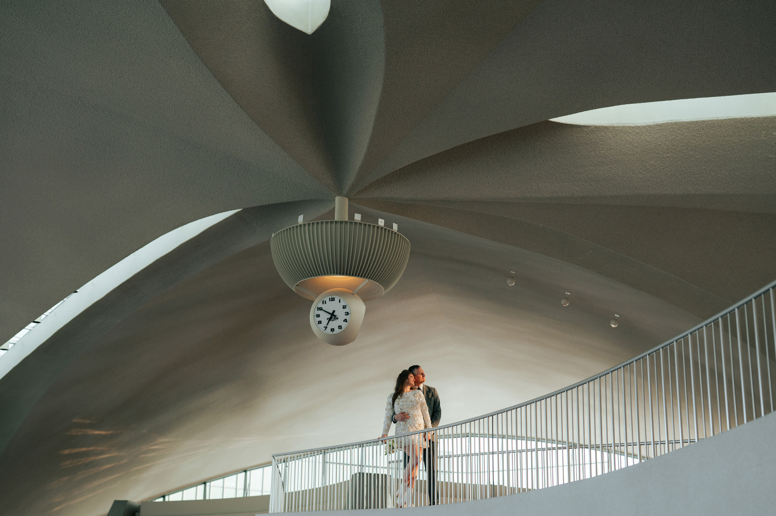 a bride and groom standing on a staircase