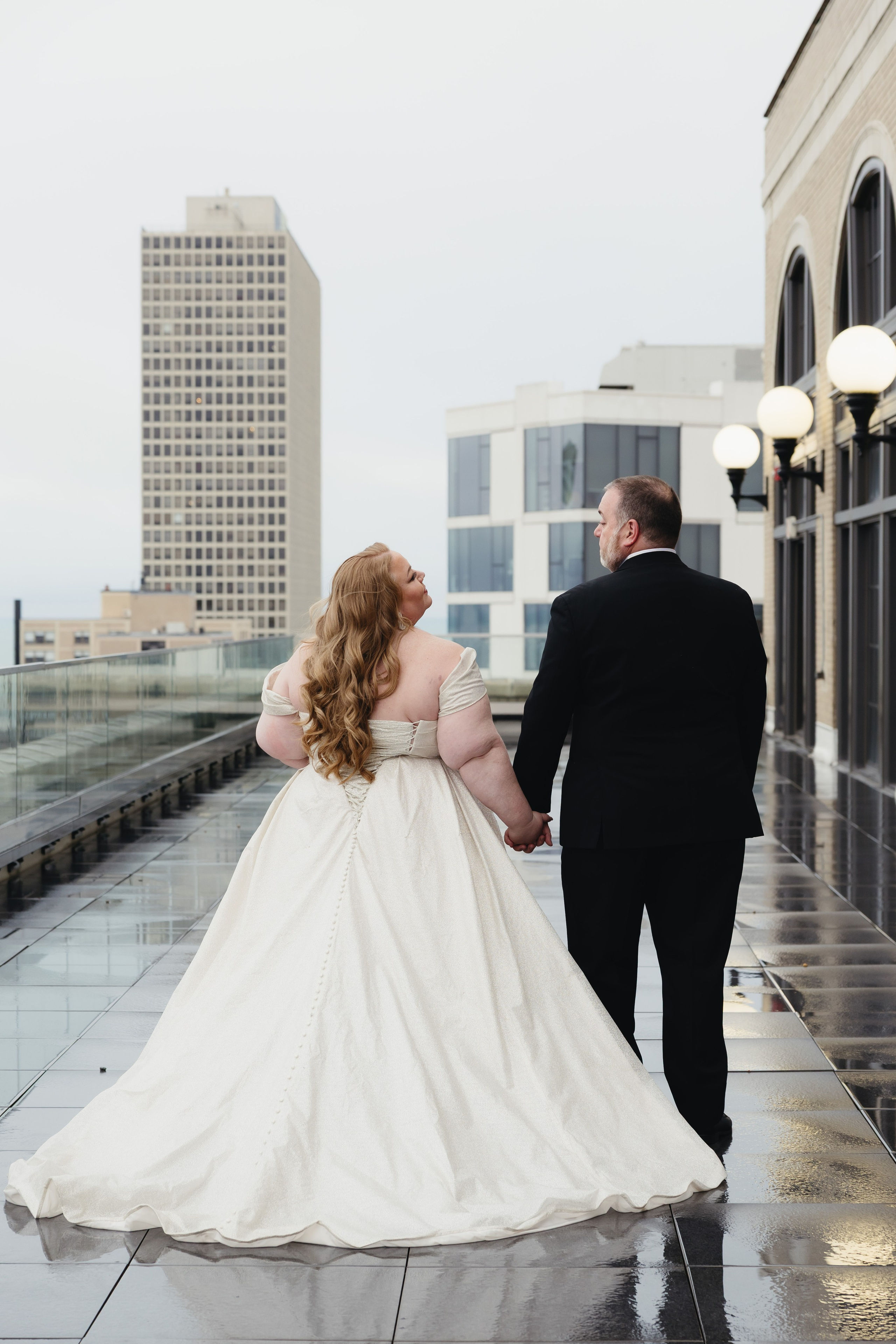 Bride and groom walking hand in hand on the rooftop at The Penthouse Hyde Park wedding venue in Chicago
