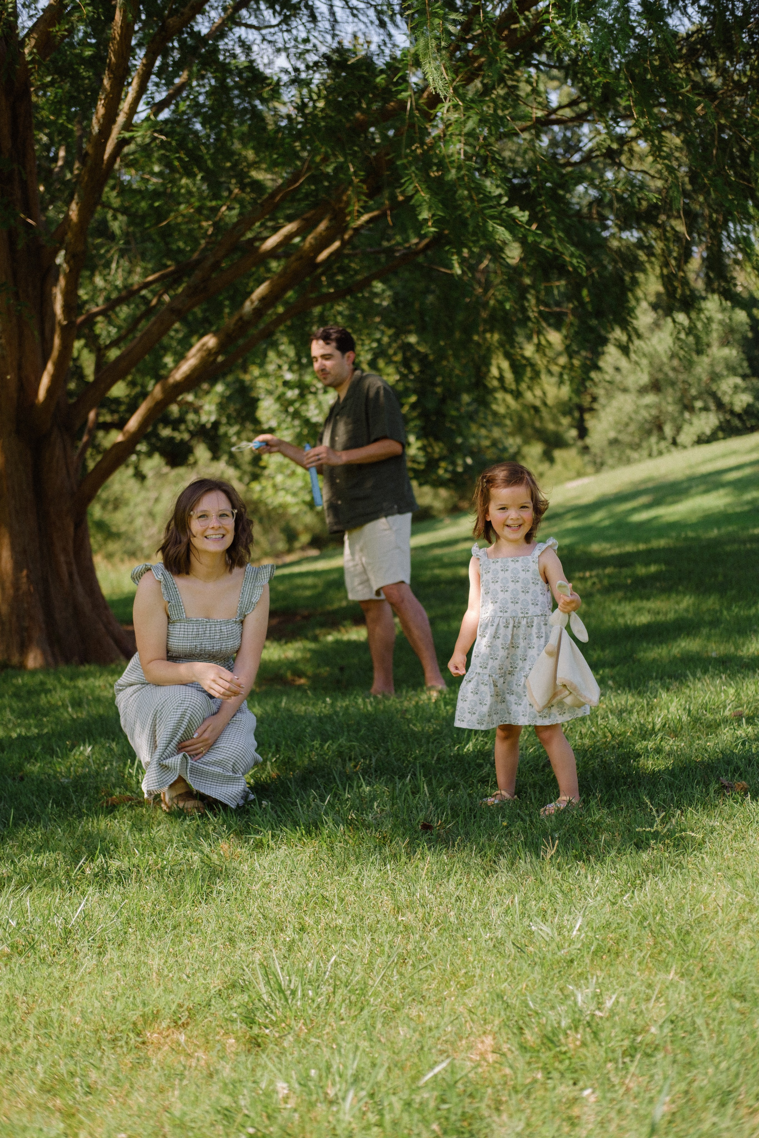 Parents are blowing bubbles with their daugher at Maymont park in Richmond, VA