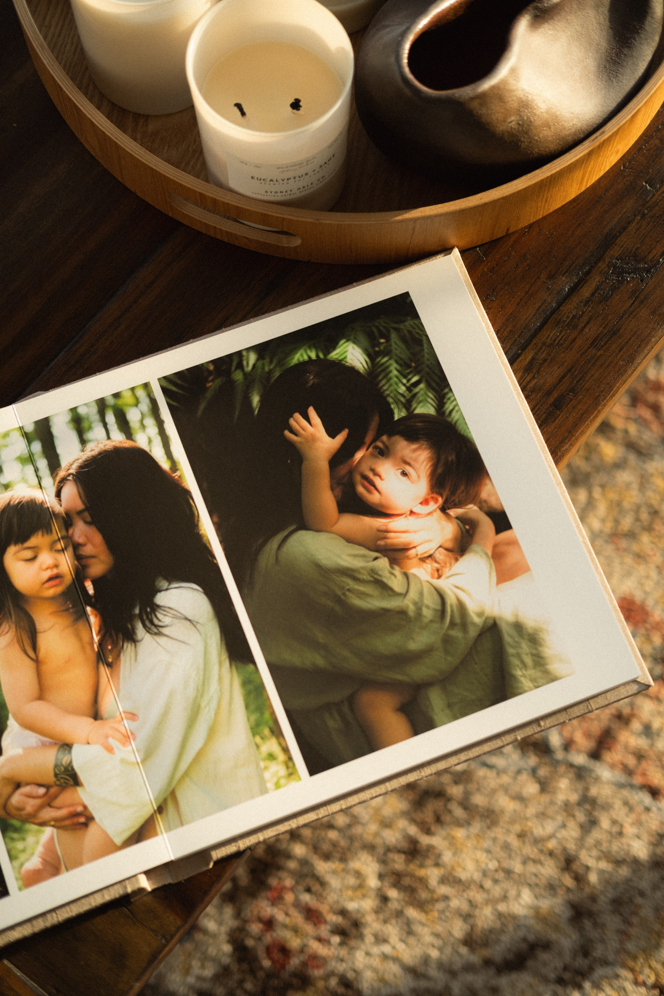 Heirloom family album opened to a full spread, displaying natural, emotional moments from a storytelling photo session