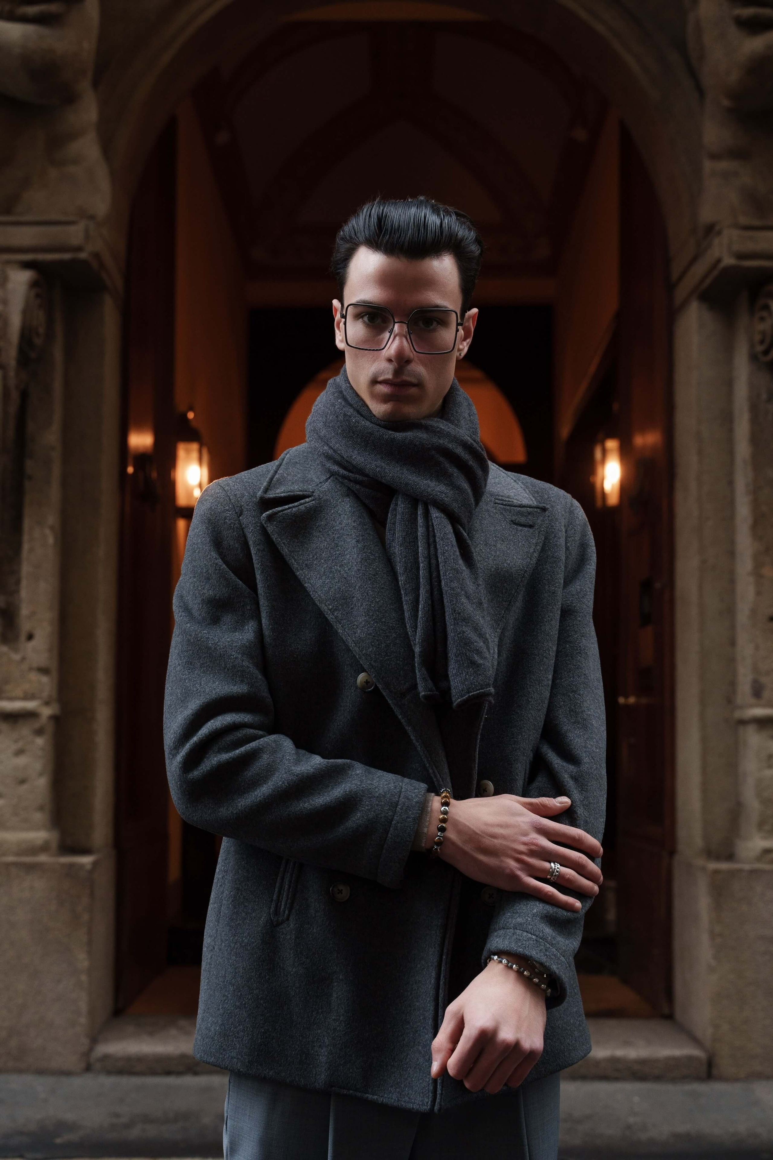 Male model in vintage-inspired optical glasses and wool coat, photographed in front of classical architecture