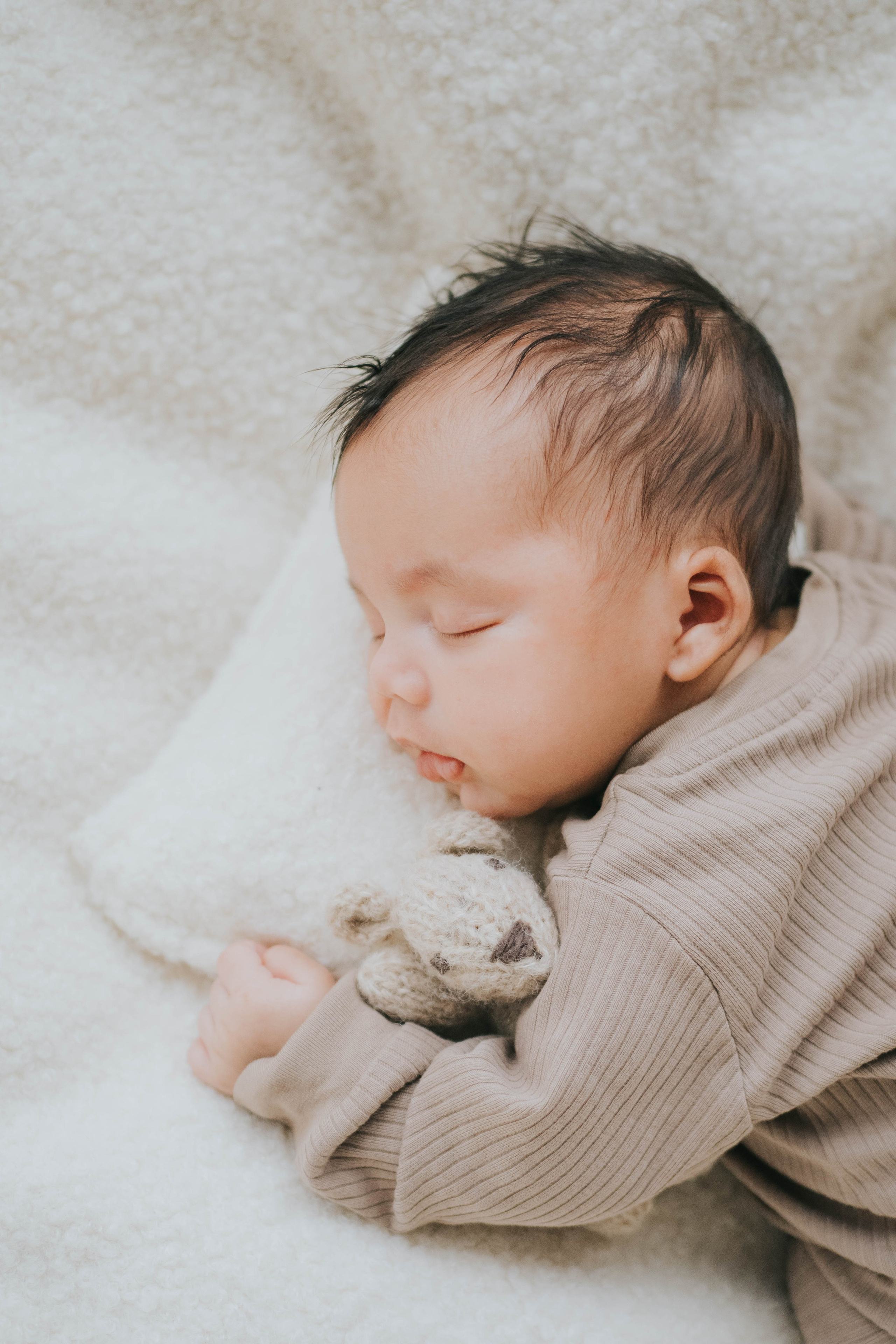 Nouveau-né avec peluche, photographie minimaliste de nouveau-nés, Mimosa Studios Montréal.