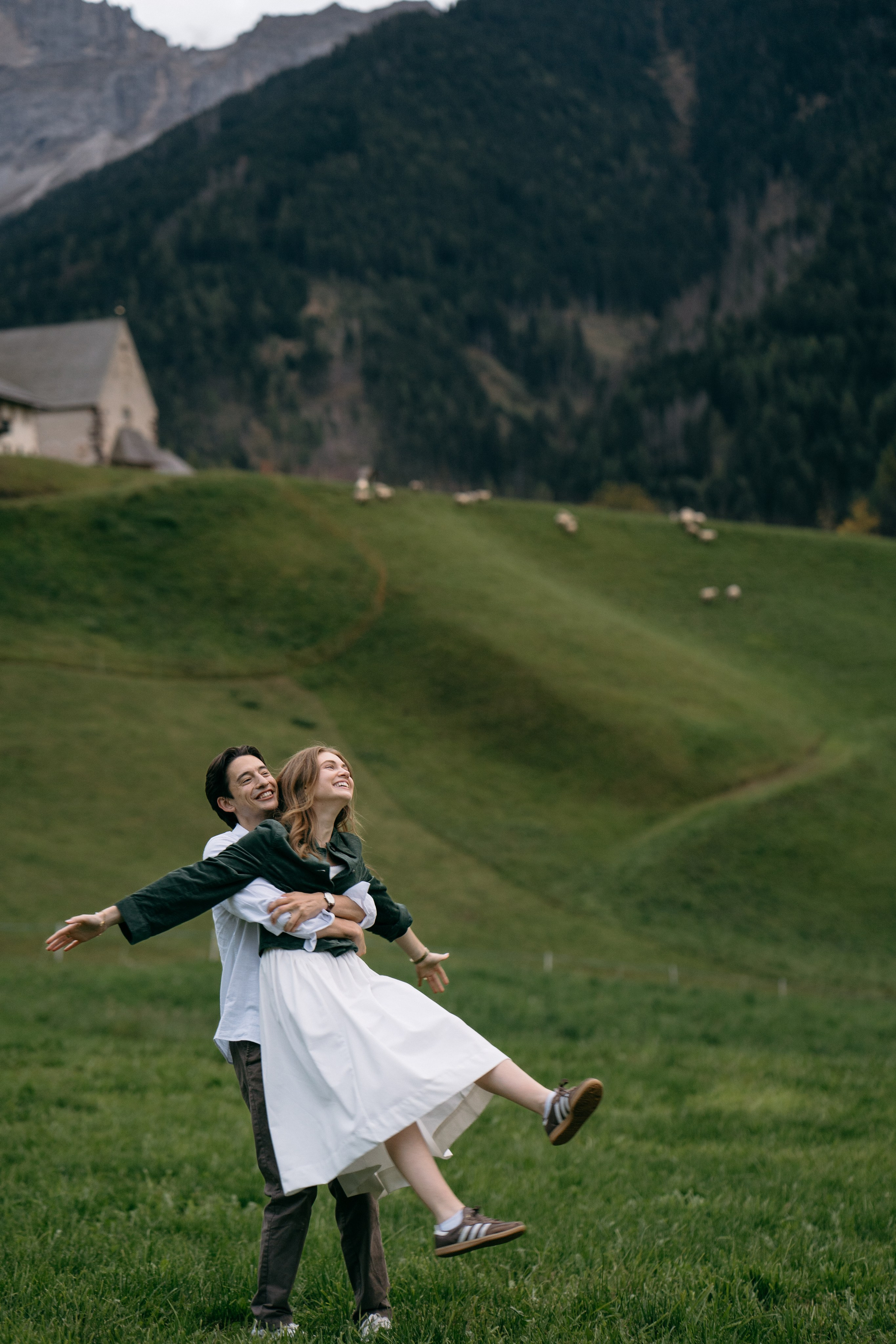 Couple walking in alpine meadow after Dolomites proposal, cinematic engagement photography in the mountains