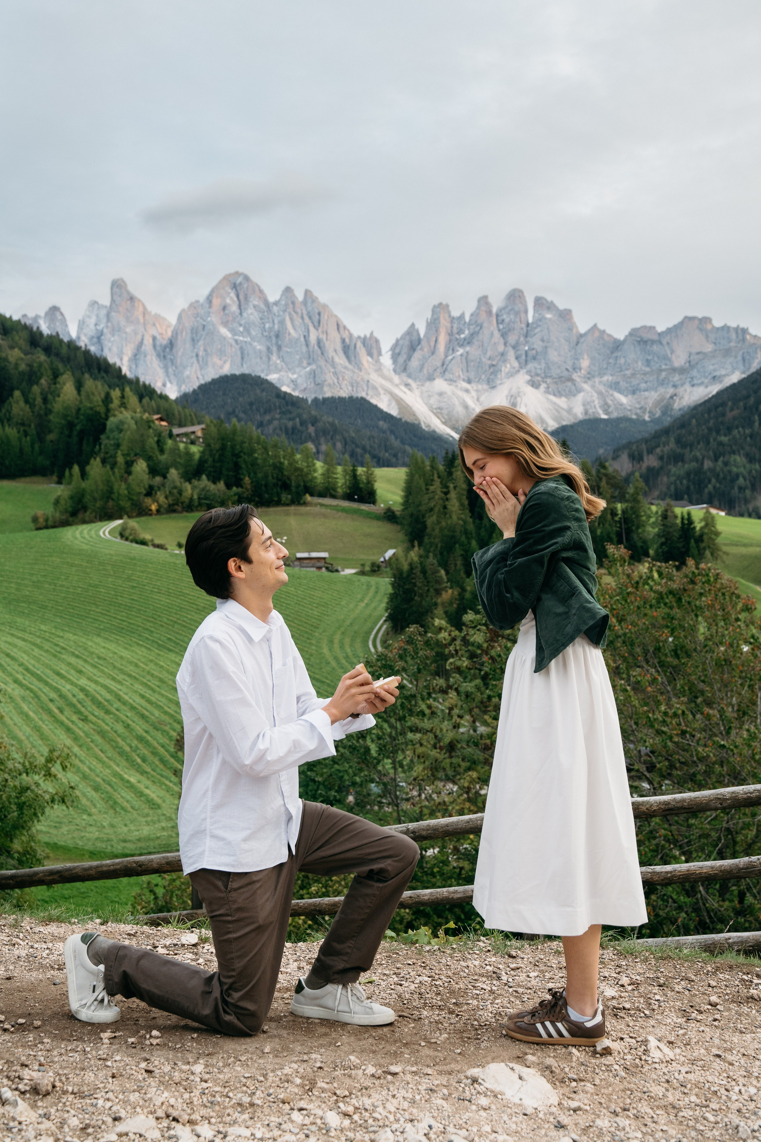Marriage proposal in the Dolomites with man kneeling in front of mountain landscape, romantic engagement in the Italian Alps