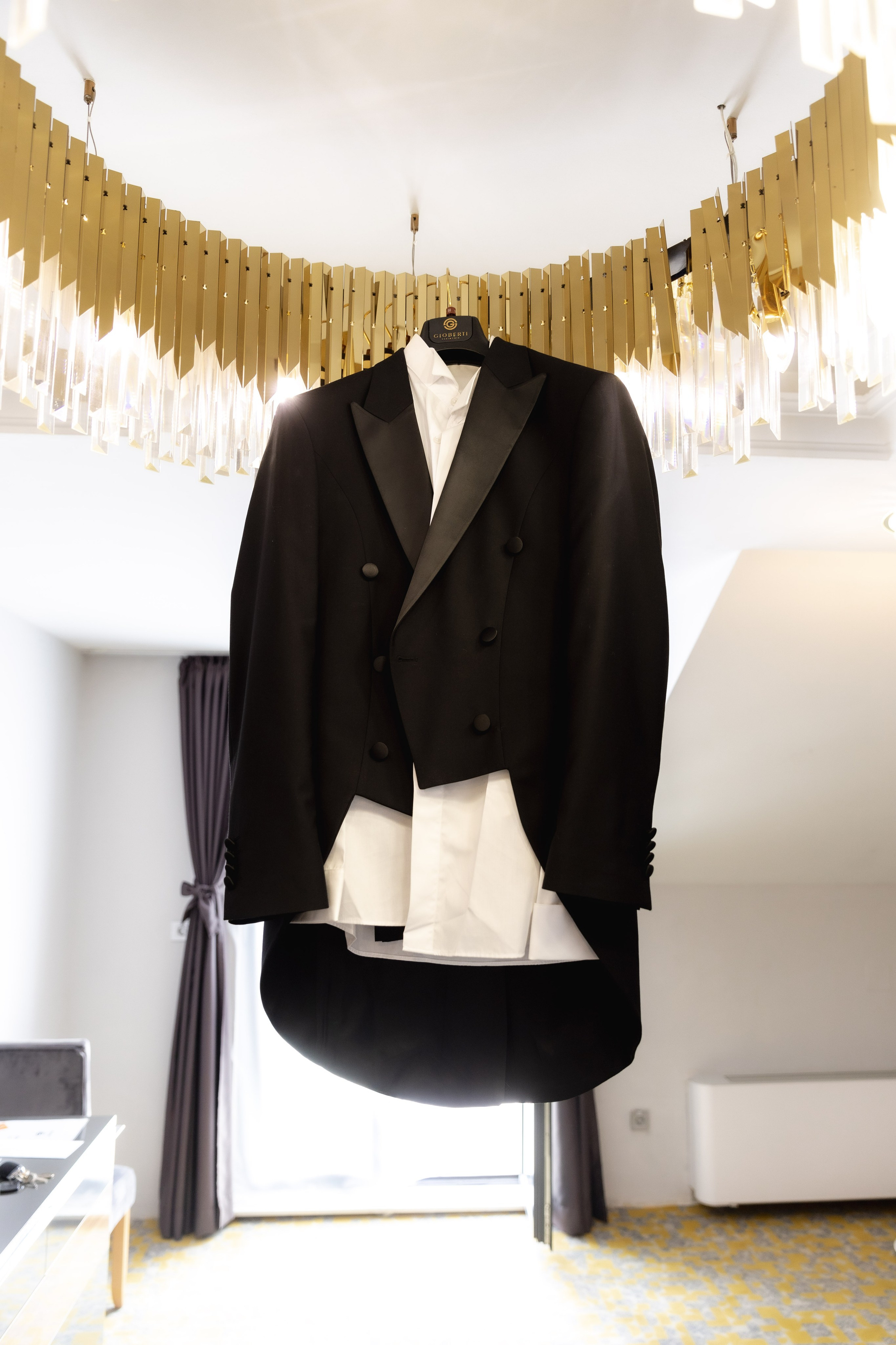 Elegant groom's suit prepared in a hotel room before the wedding, capturing a refined detail of the wedding day preparations.