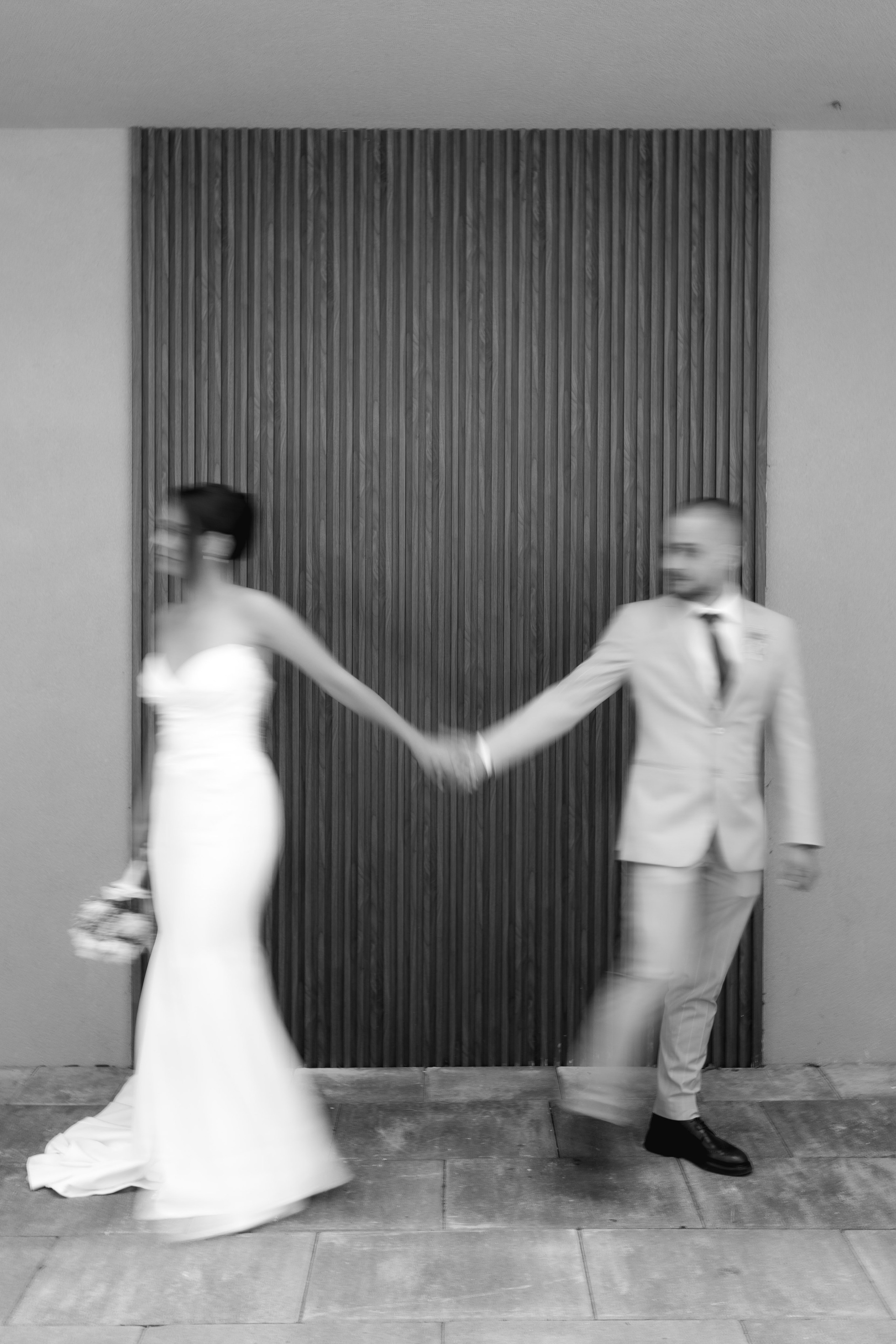ride and groom holding hands in an artistic motion blur, capturing an authentic and emotional wedding photography moment.