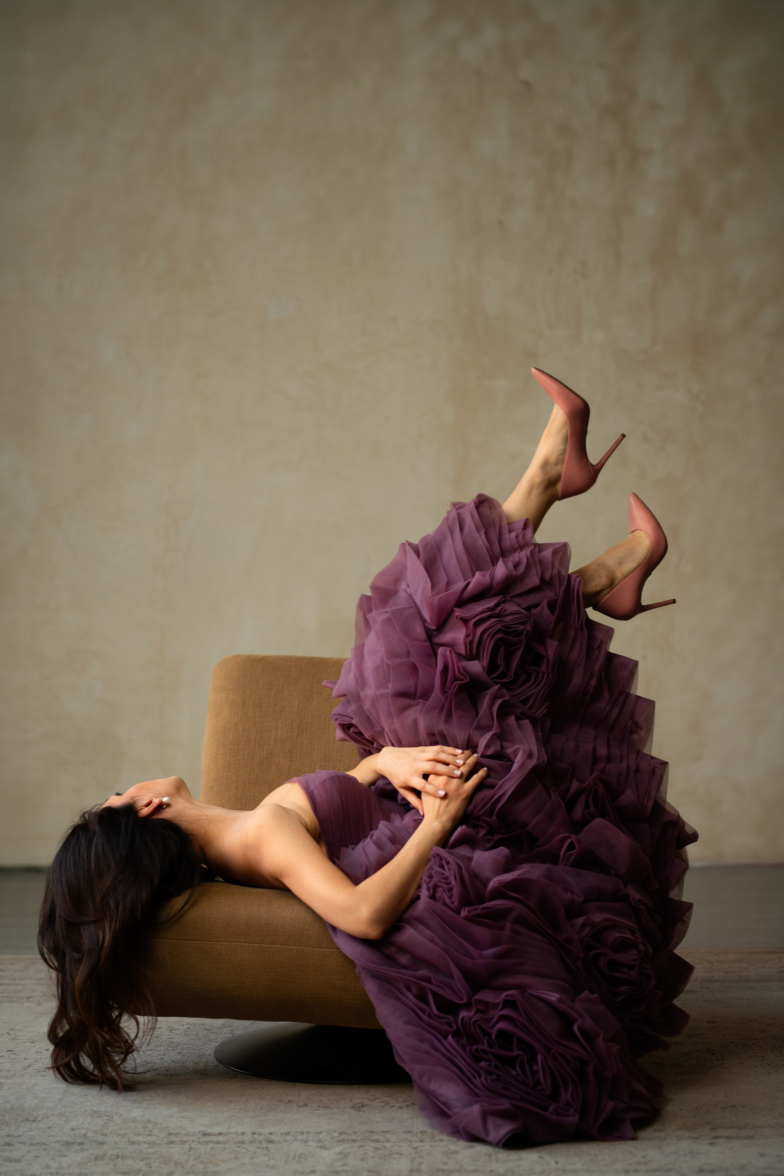 žena u ljubičastoj aljini sa podignutim nogama u neobičnoj pozi na fotelji