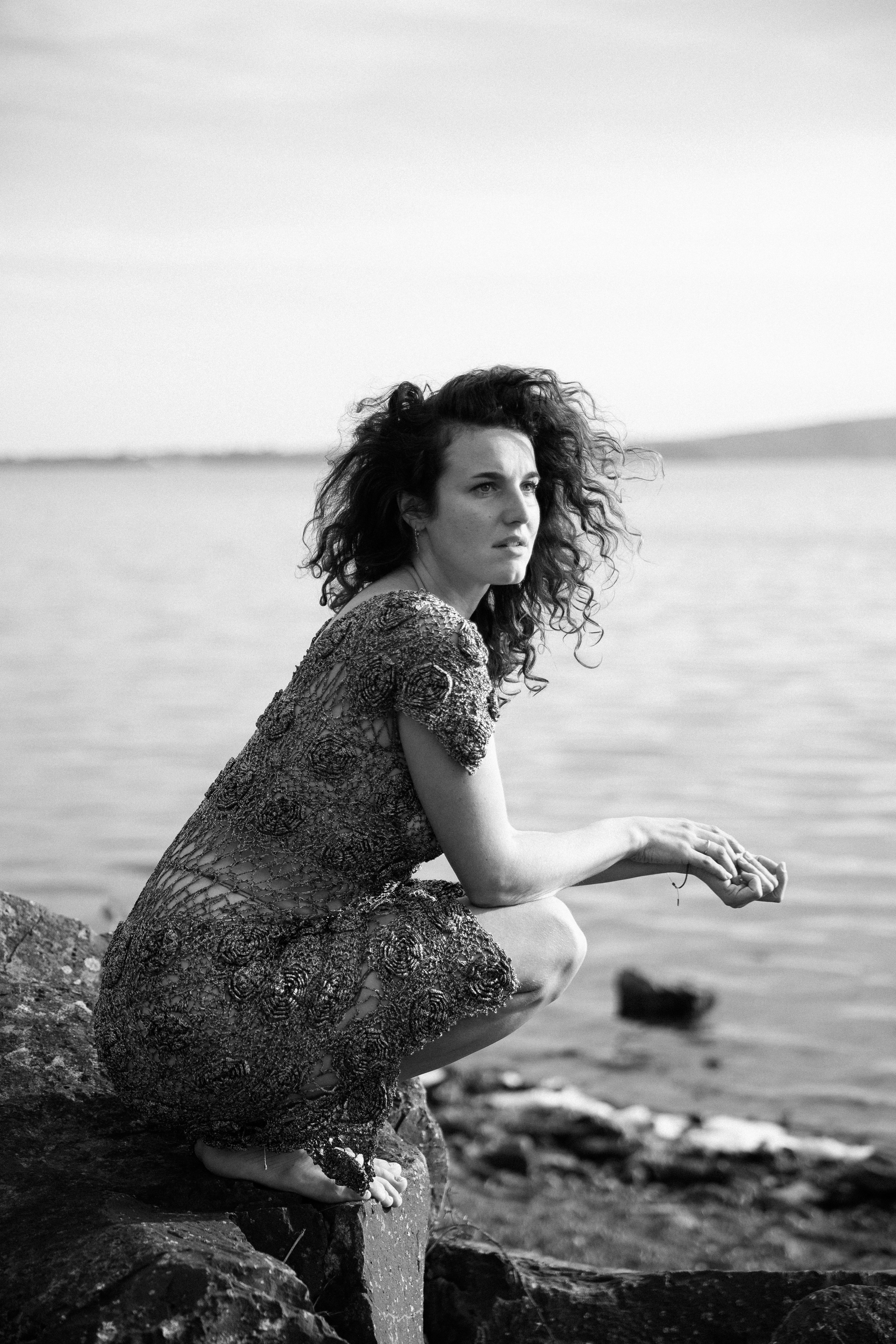 A woman in thoughts at the serene lake in Rome.