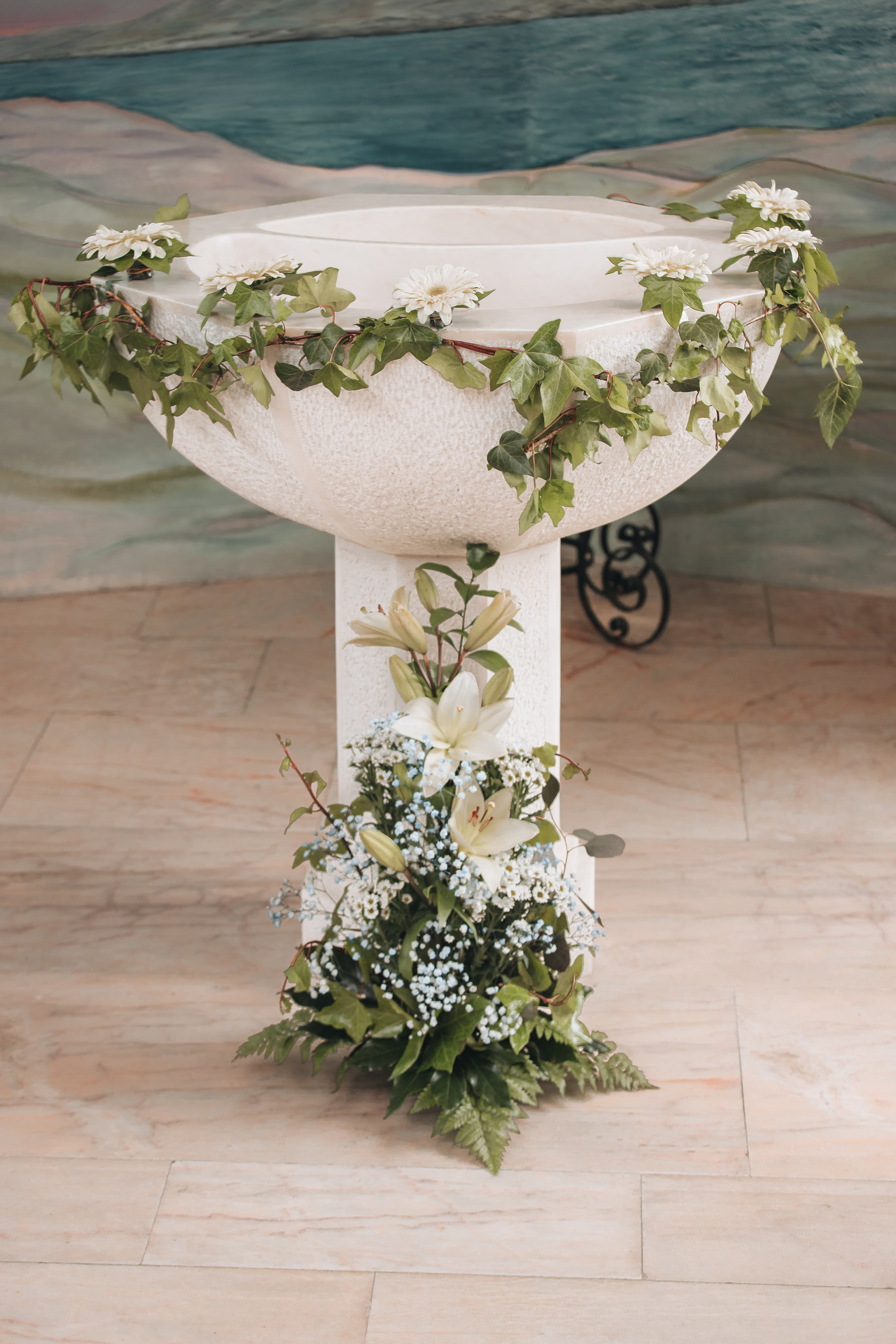 Pia batismal decorada numa igreja durante cerimónia de batismo em Portugal