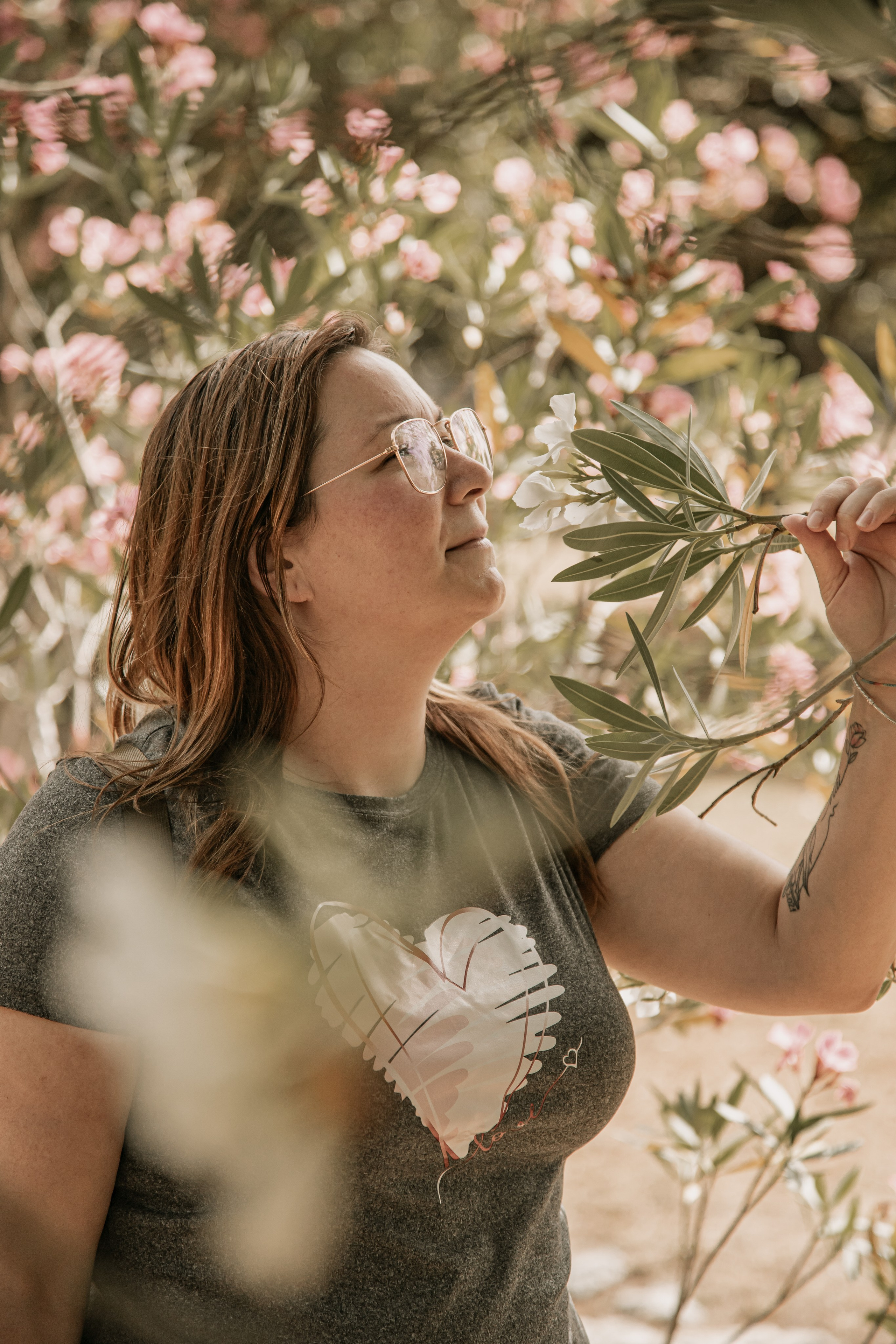 Mulher a Cheirar uma flor no jardim