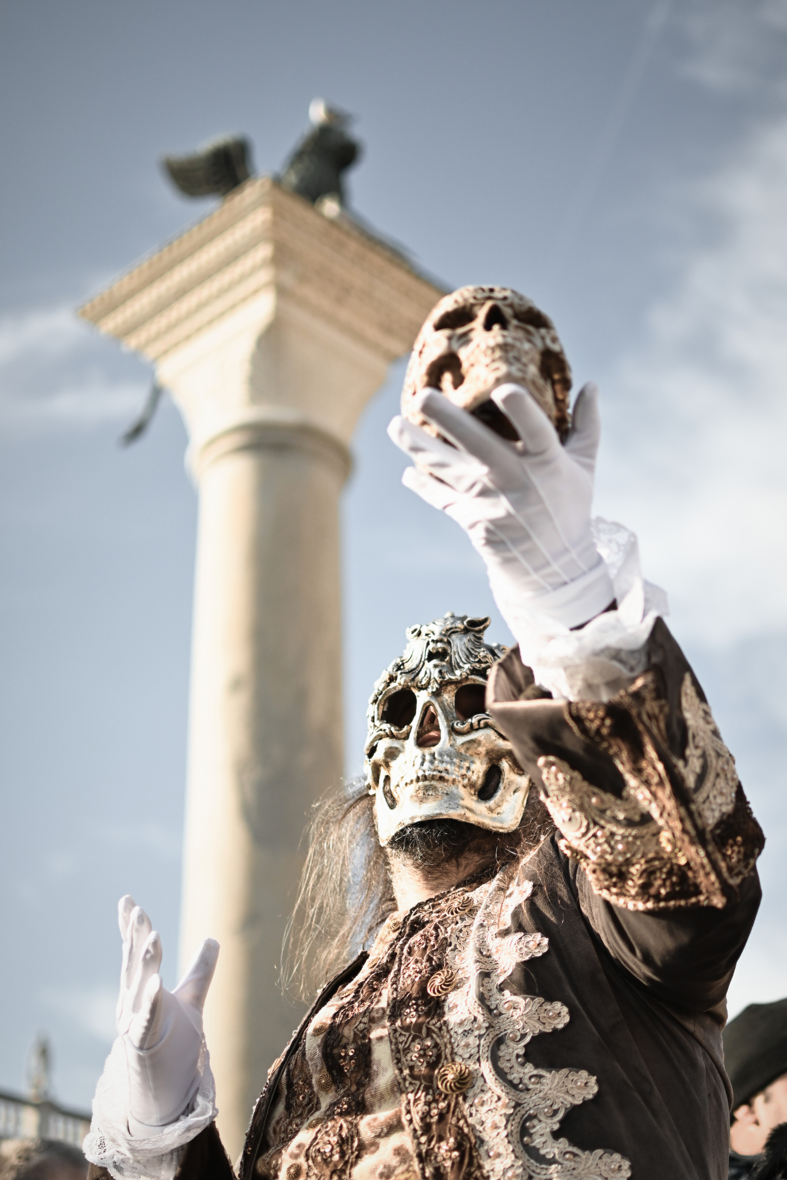 performer entertaining the crowd with juggling at Venice Carnival. A close-up of a carnival costume with beaded details and intricate embroidery.