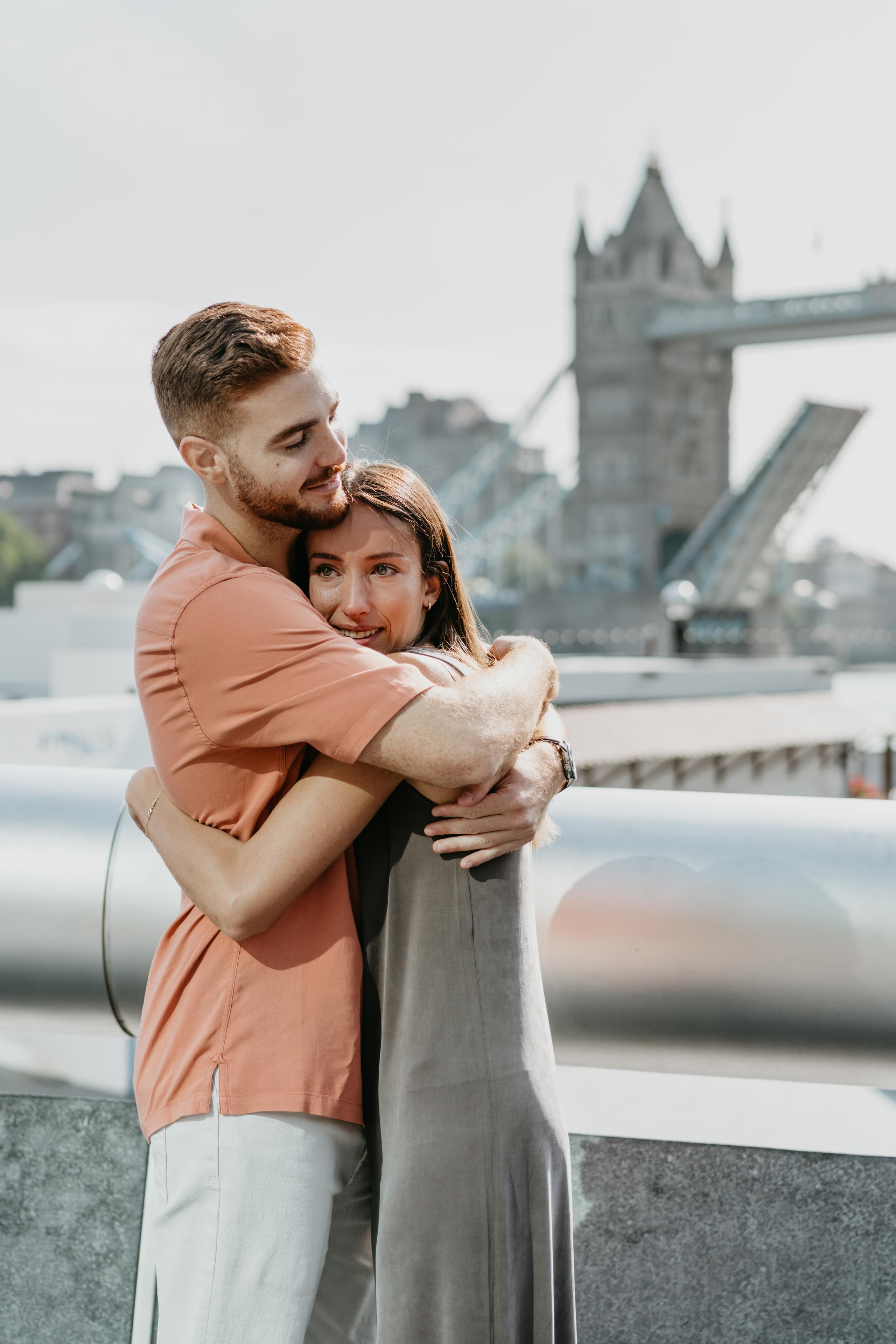 young couple hugging with tower bridge on the background