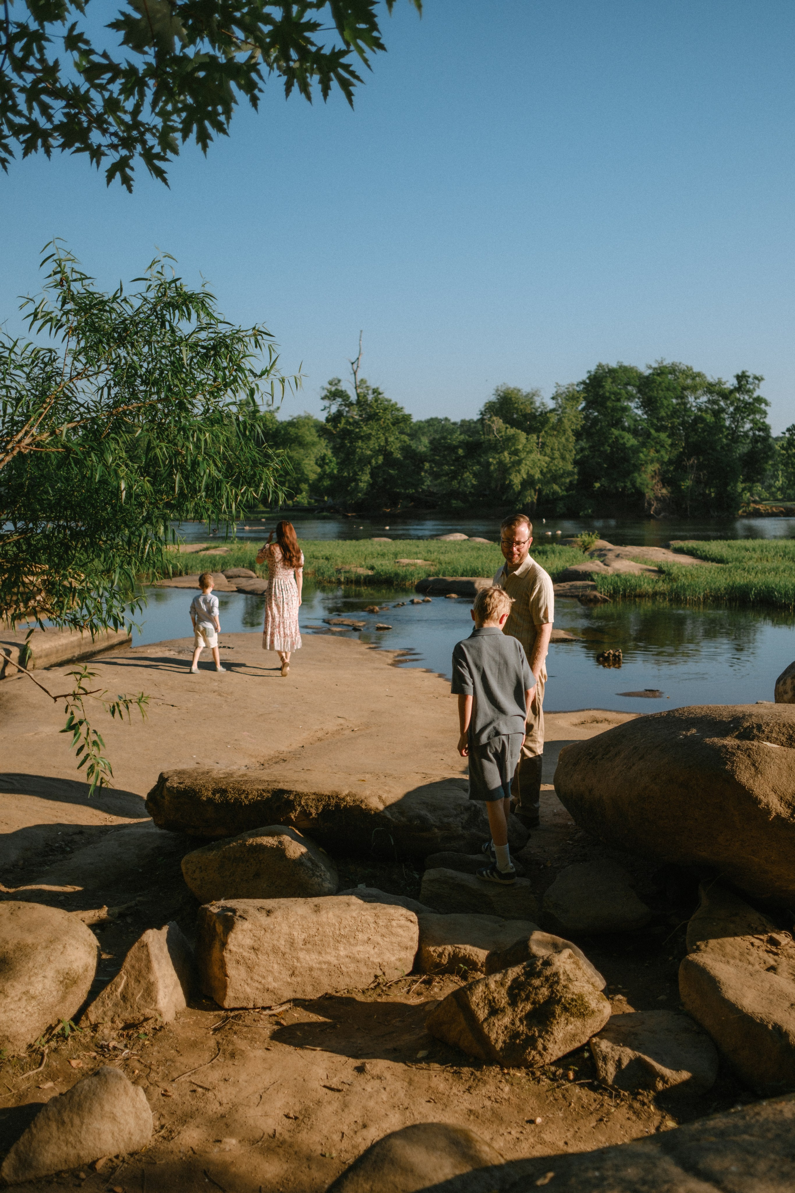 An adventurous family playing in the shallow water during a lifestyle photography session on the James River in RVA