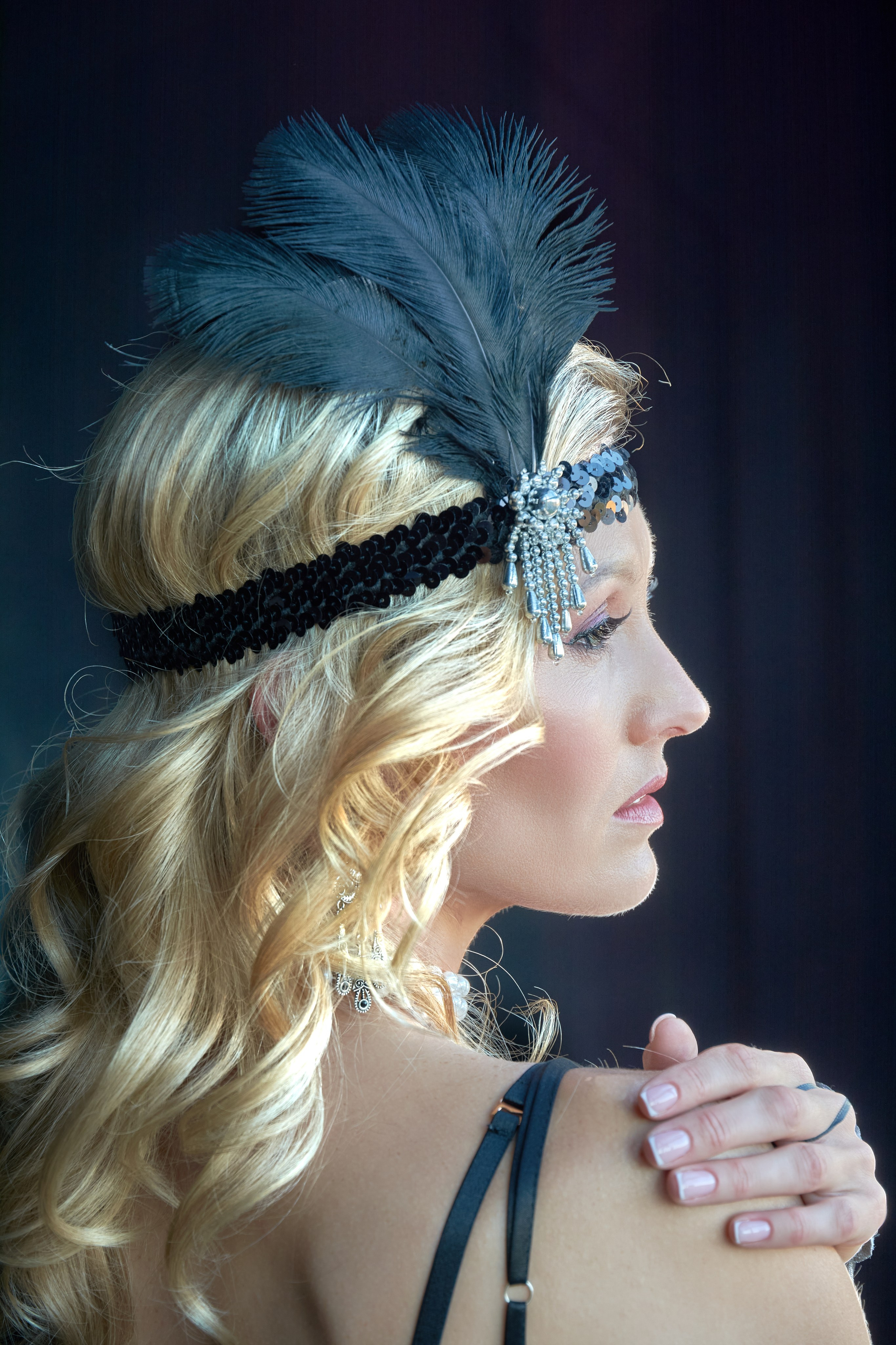 Profile portrait of a woman in a feathered headpiece — from "Flappers: A Transformation"