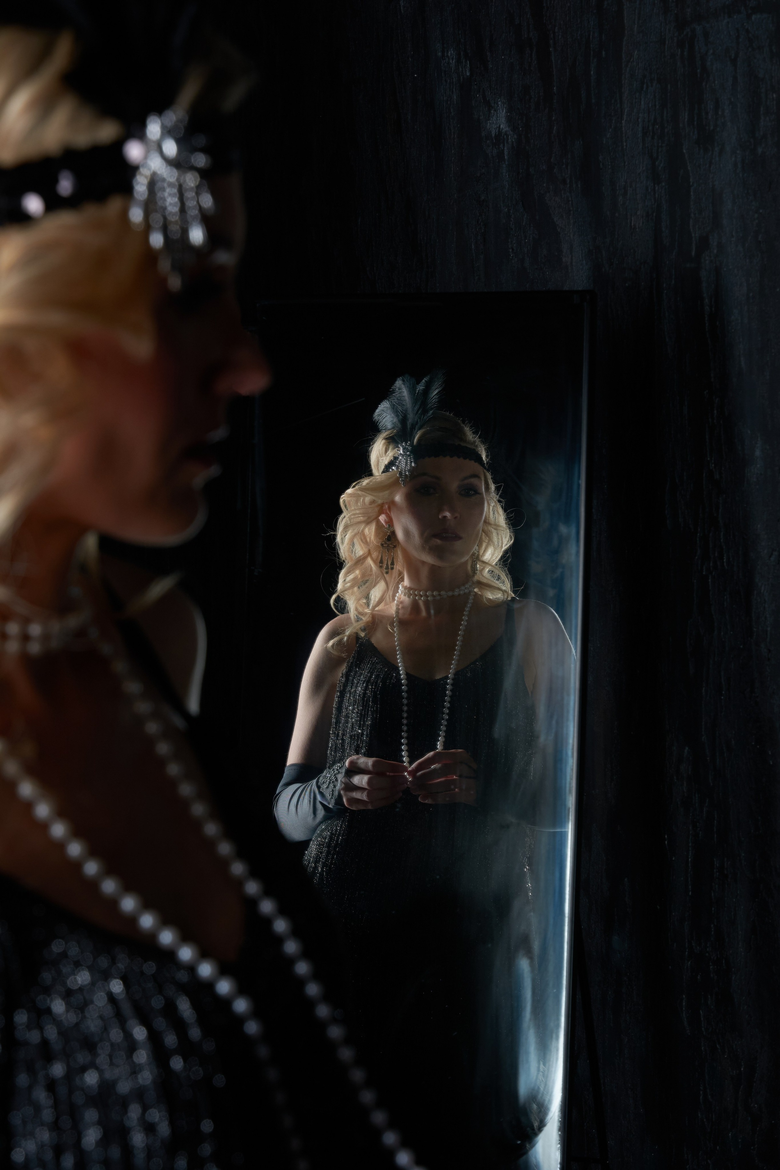 A flapper gazes at her reflection in a mirror — a scene of inner dialogue