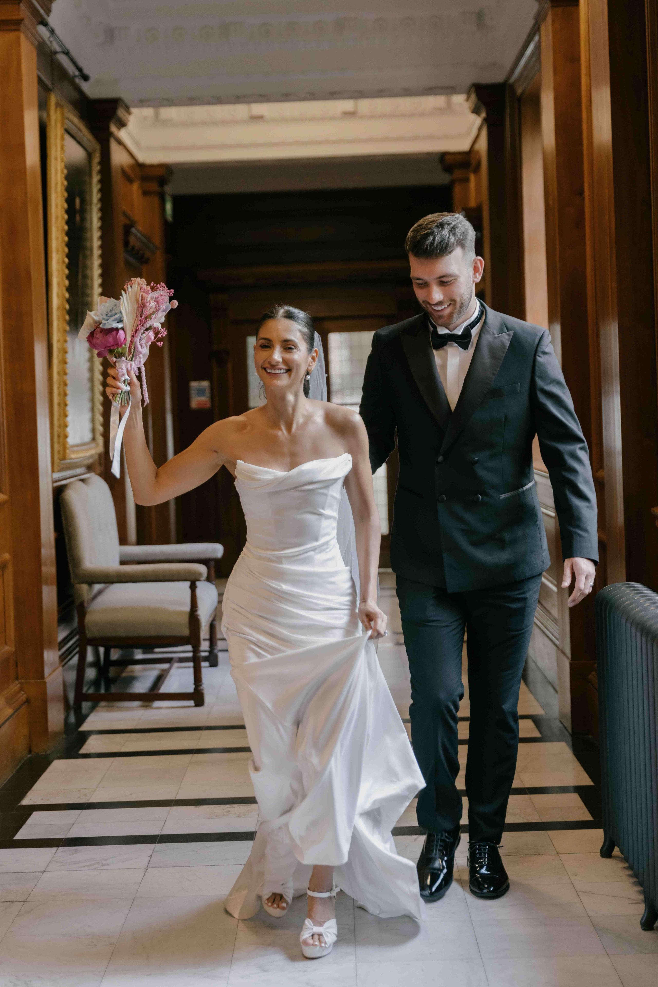 Bride and groom walking through elegant hotel interior on wedding day