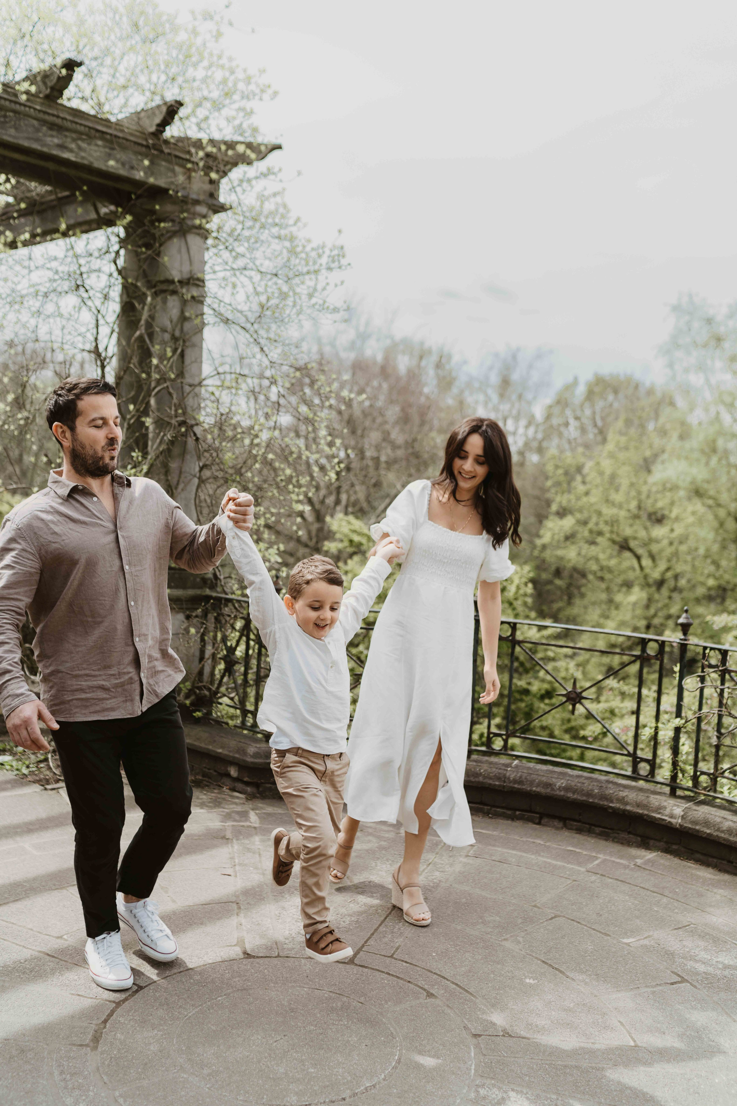 Family walking together at Hampstead Pergola London in coordinated beige and cream outfits.