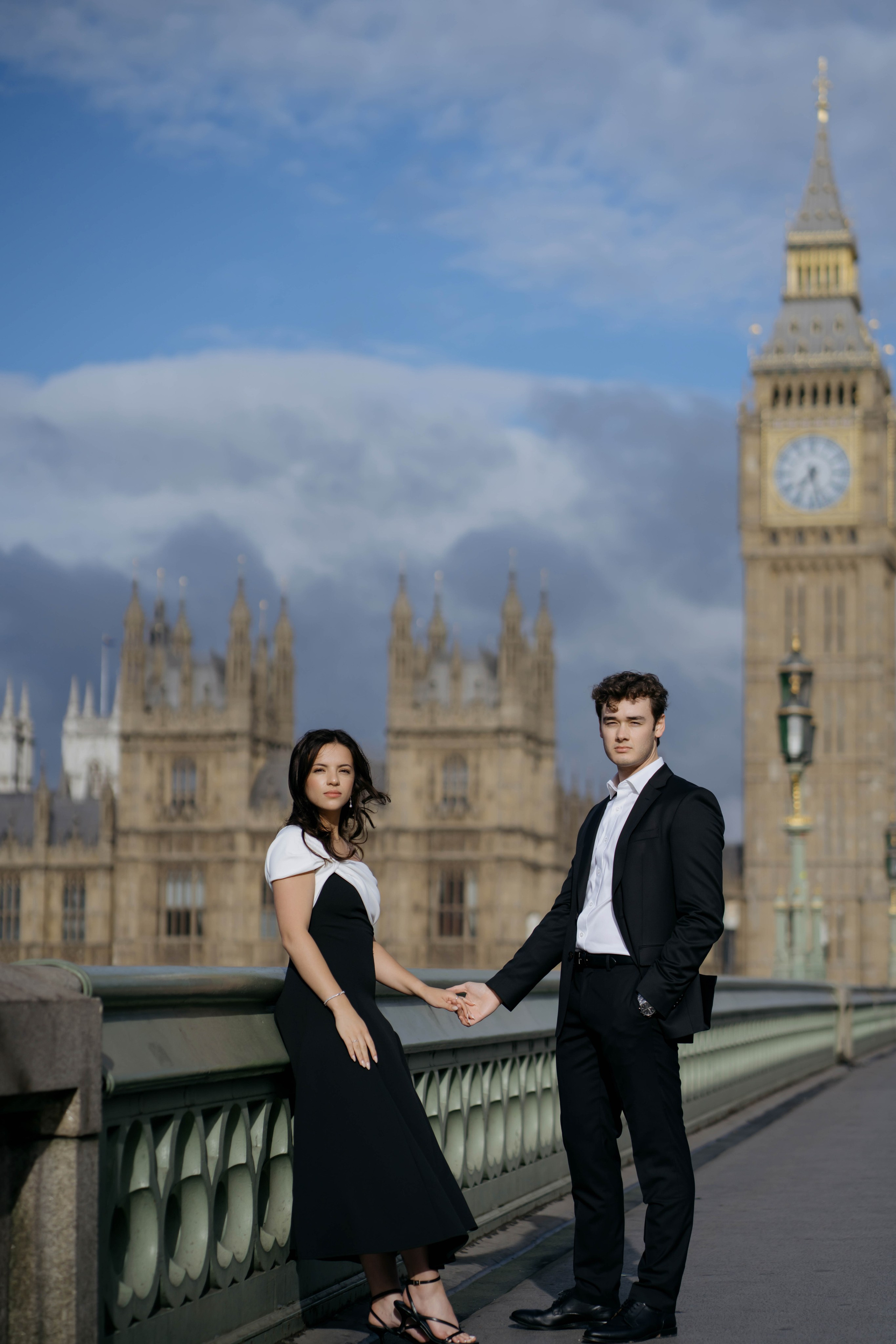Couple photoshoot in London near Big Ben wearing elegant black outfits at sunset.