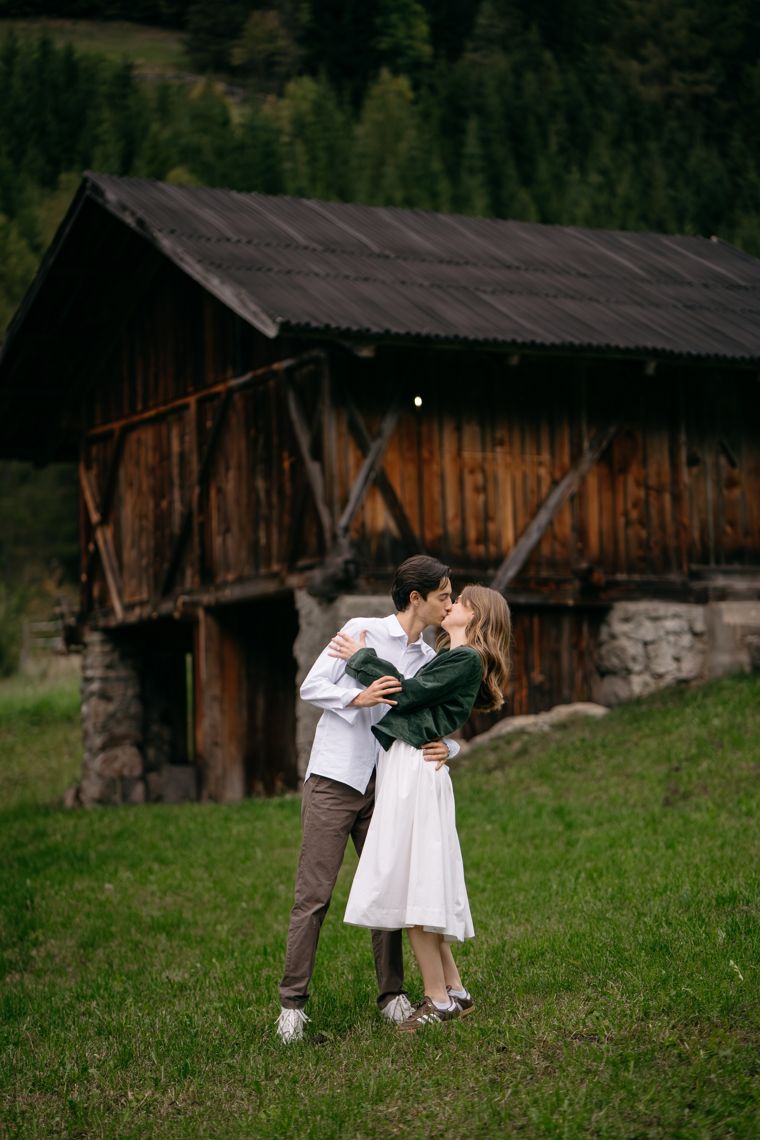 Couple celebrating proposal near alpine cabin in the Dolomites, intimate mountain engagement in Italy