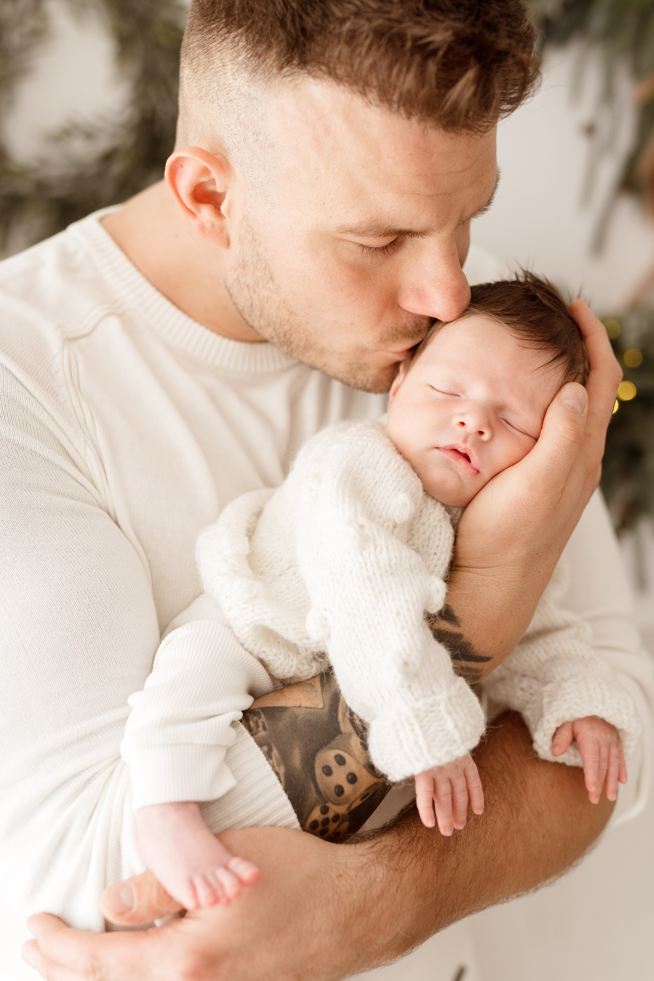 Sesje świąteczne w Łodzi – rodzice tulący dzieci w bajkowej, zimowej scenerii