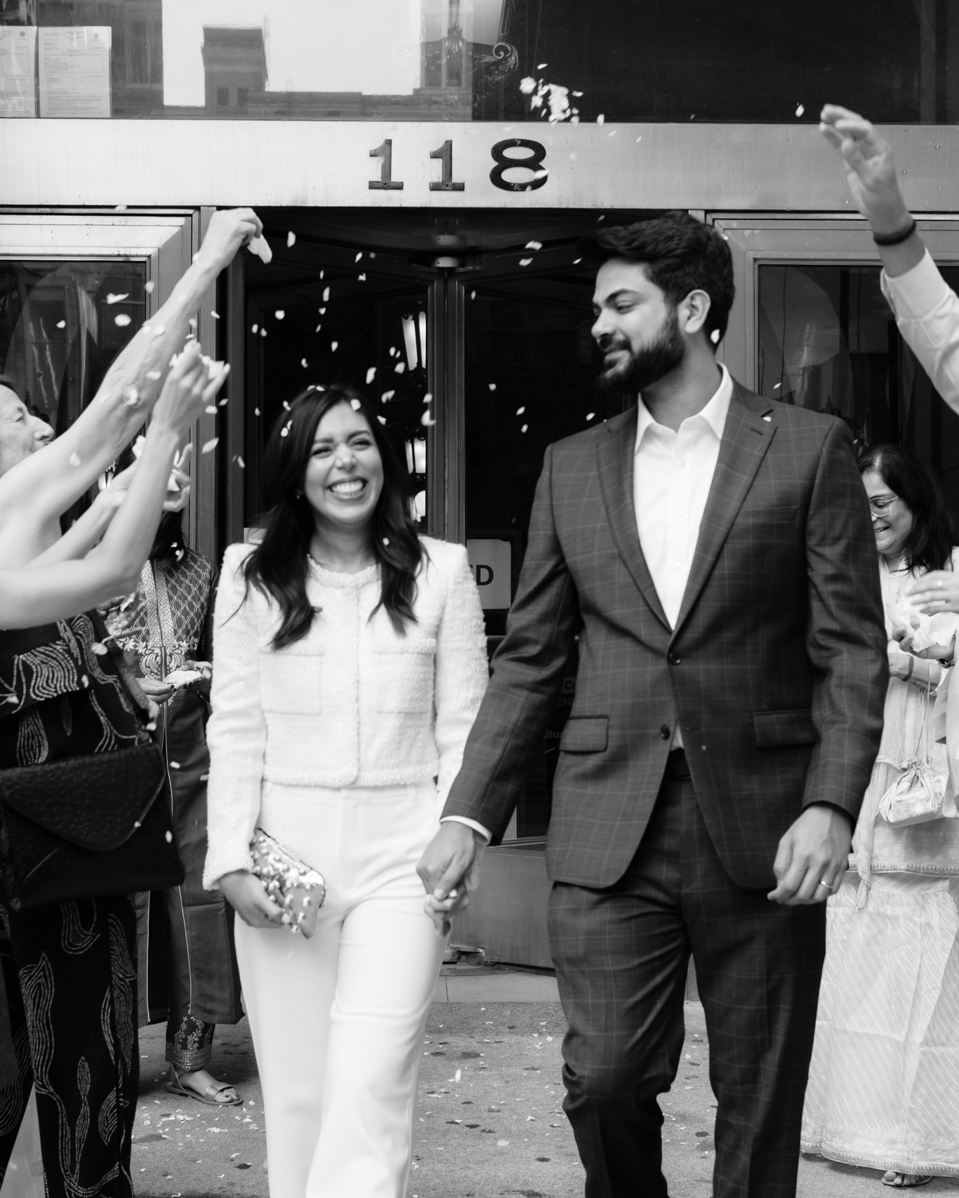 Close-up of a just married couple leaving Chicago City Hall, greeted by cheering guests