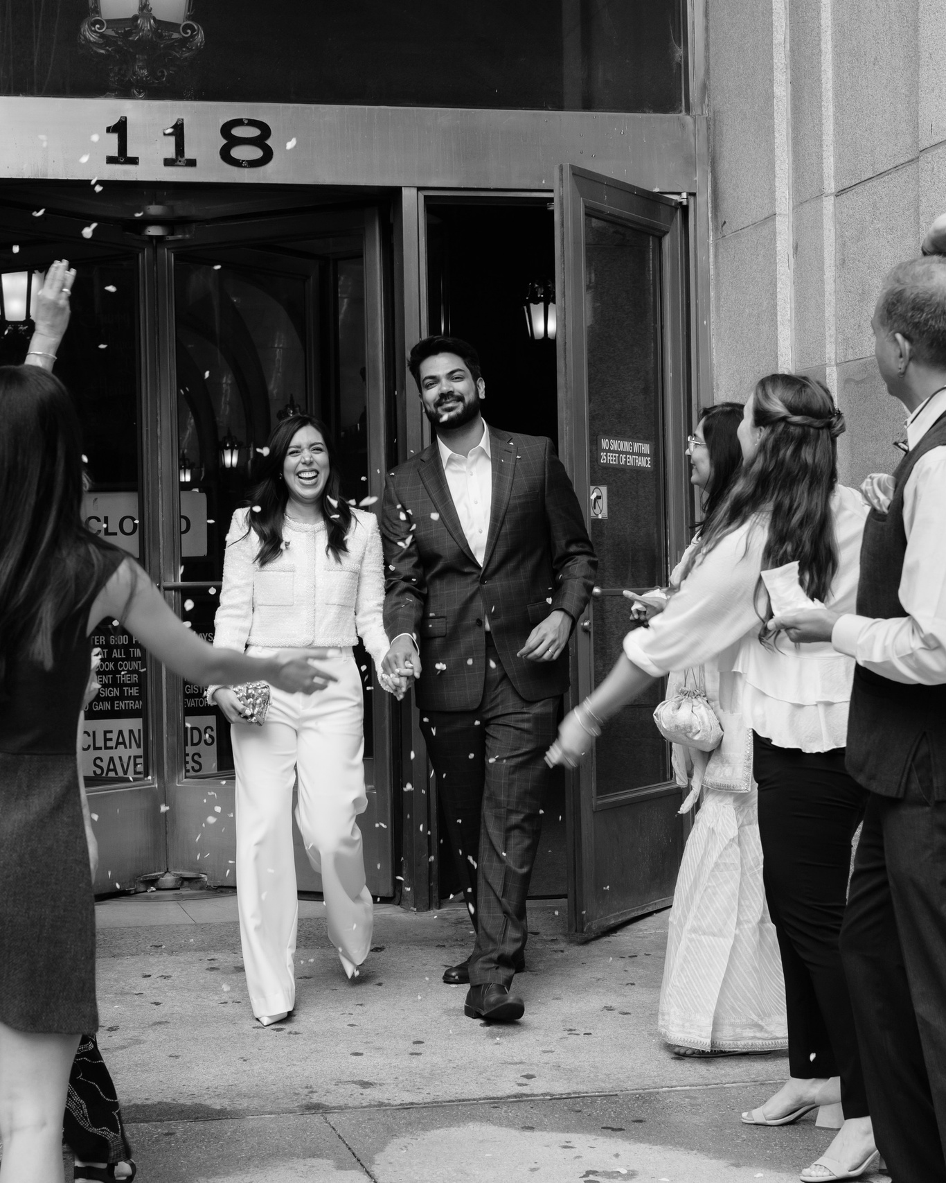 Just married couple walking out of Chicago City Hall as friends and family celebrate their elopement